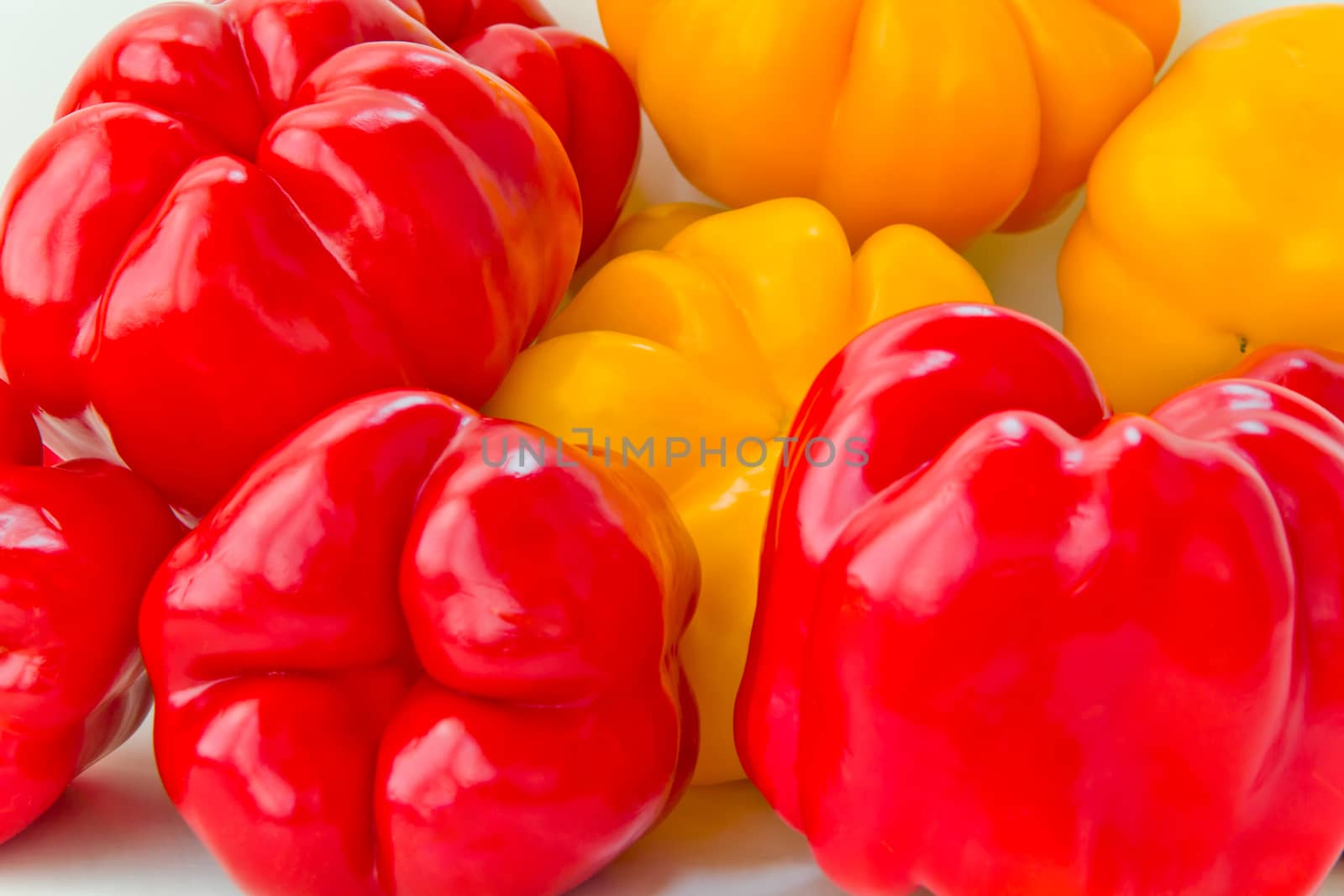 Photo of red and yellow raw pepper on white background