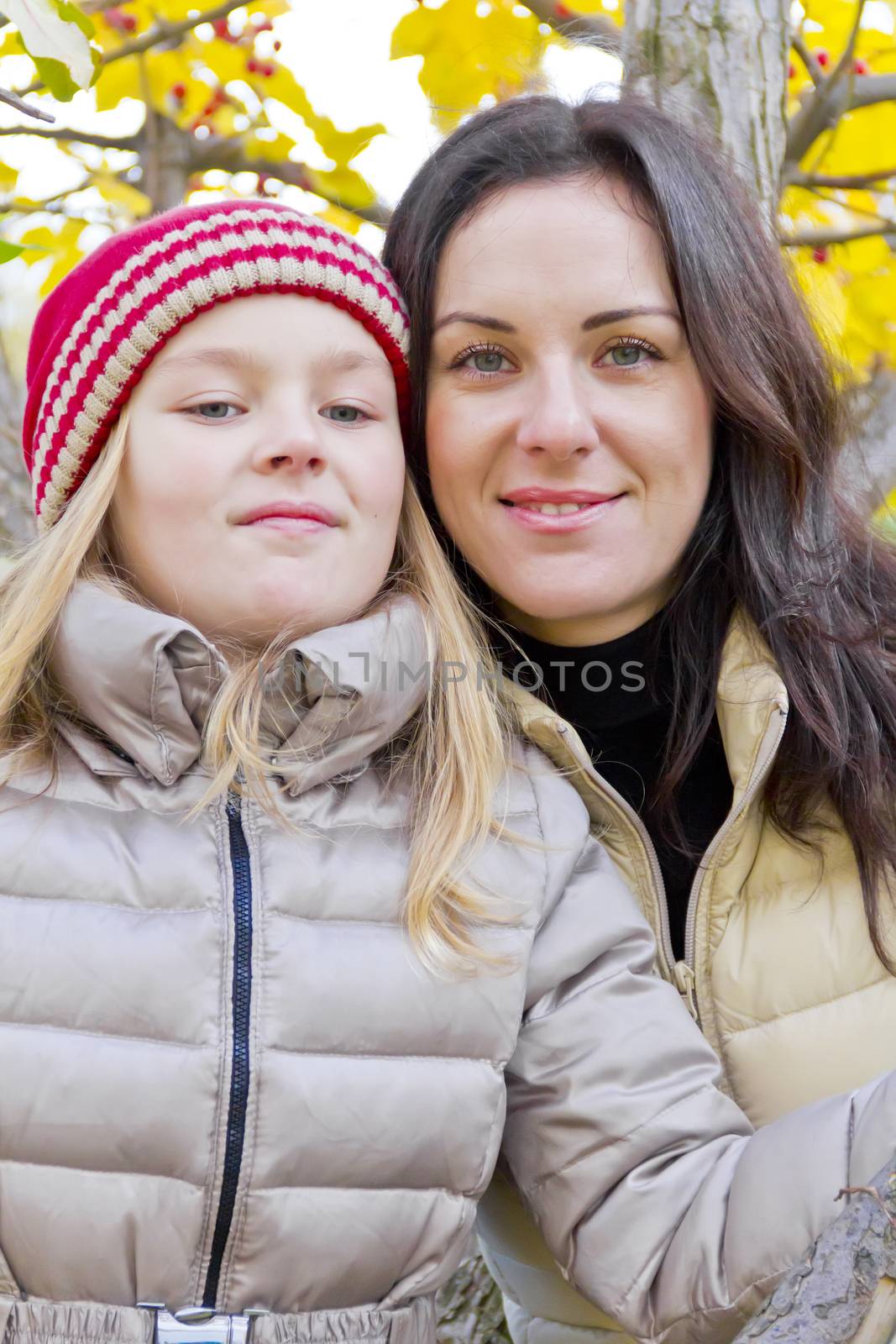 Mother and daughter on yellow foliage background