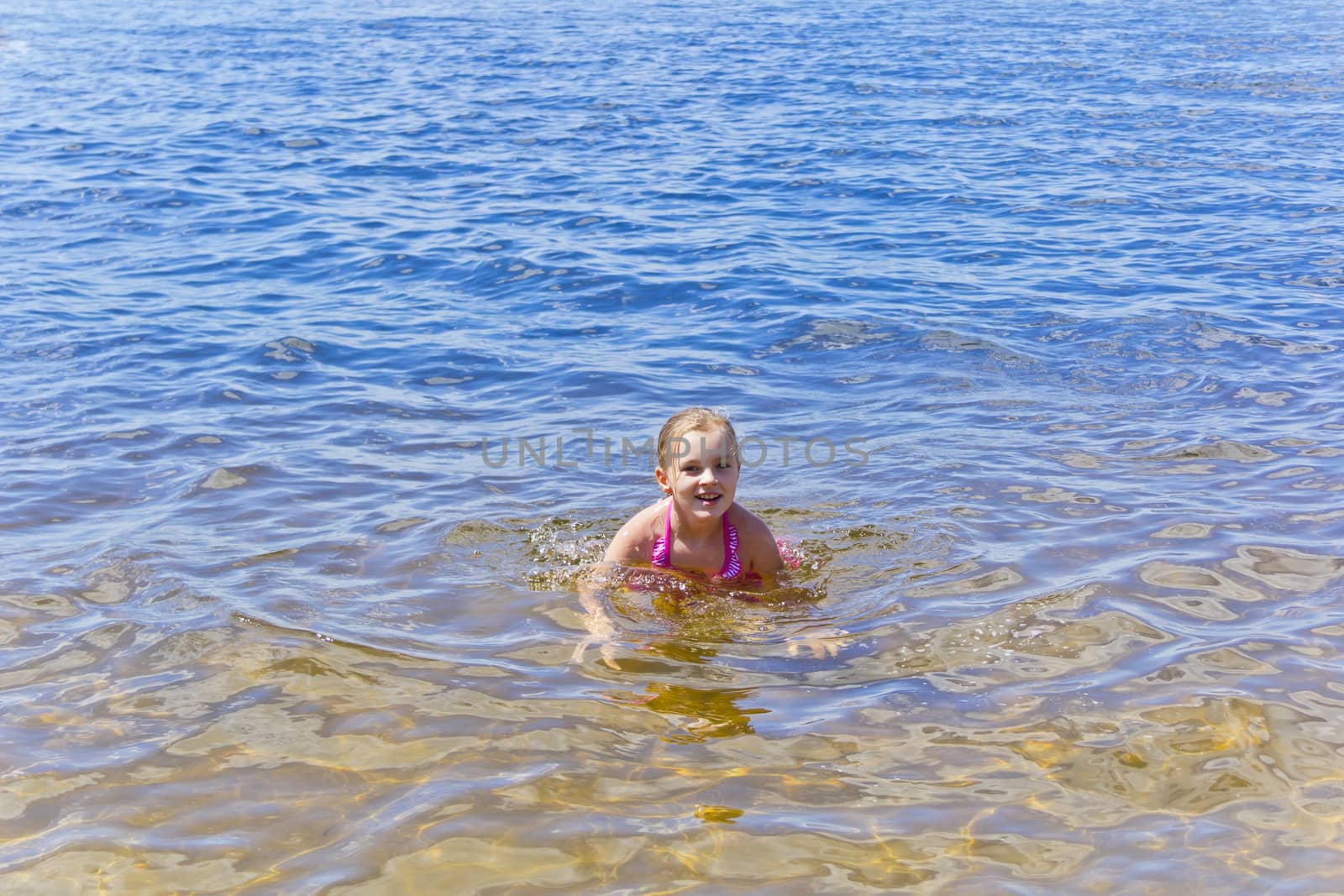 Swimming smiling cute girl seven years old