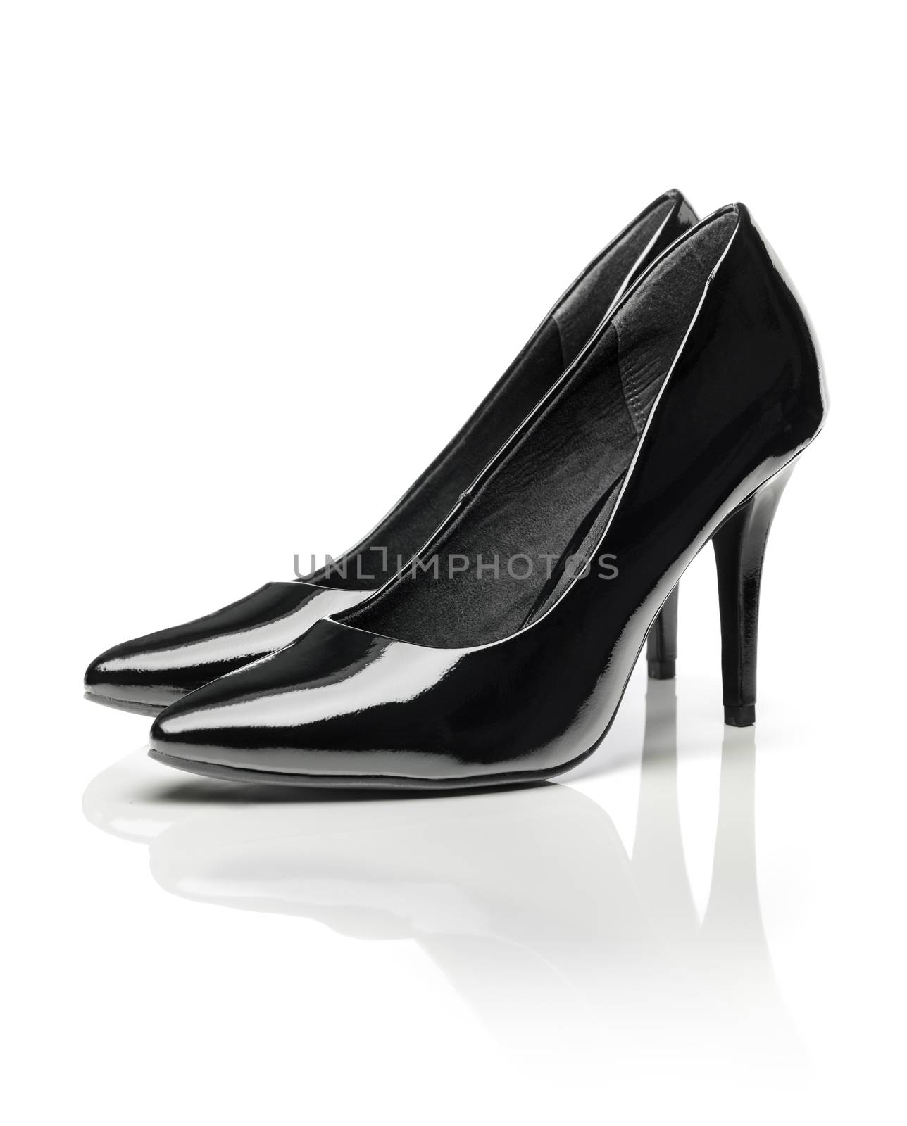 Black shiny patent leather stiletto heel pumps isolated on white with natural reflection.