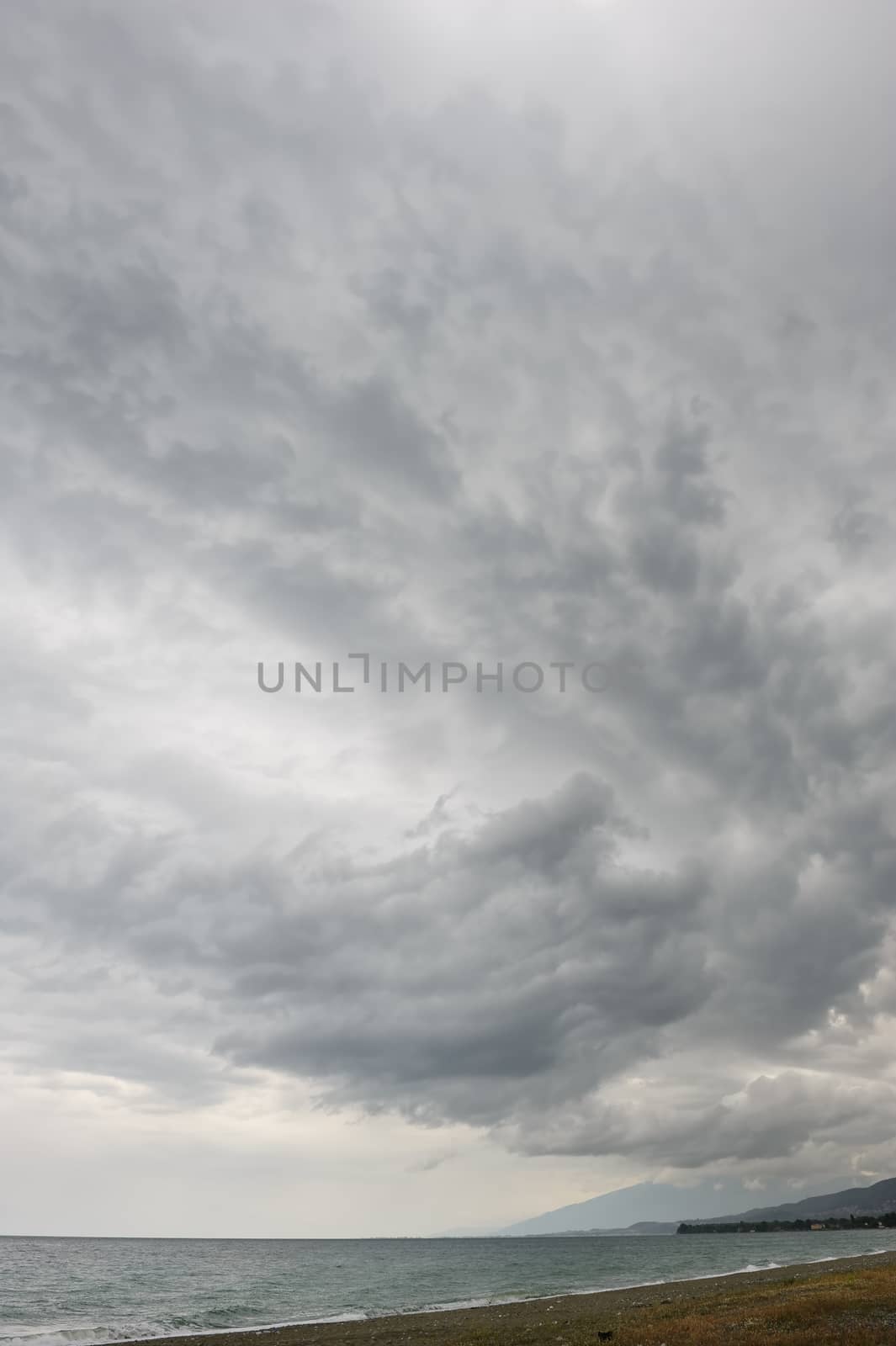 rainstorm, heavy overcast raiclouds over the sea beach