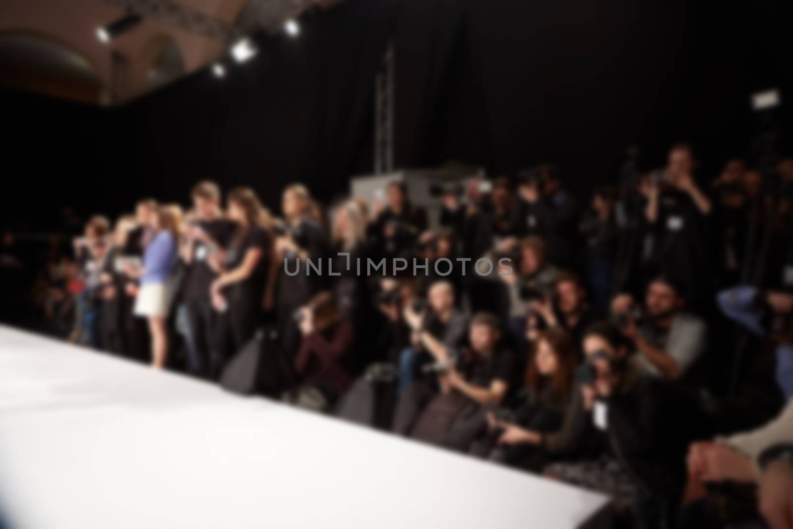 blurred image of group of audience at fashion show stage