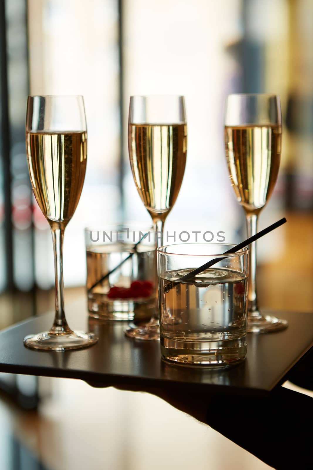 Three glasses of champagne with lights in the background.