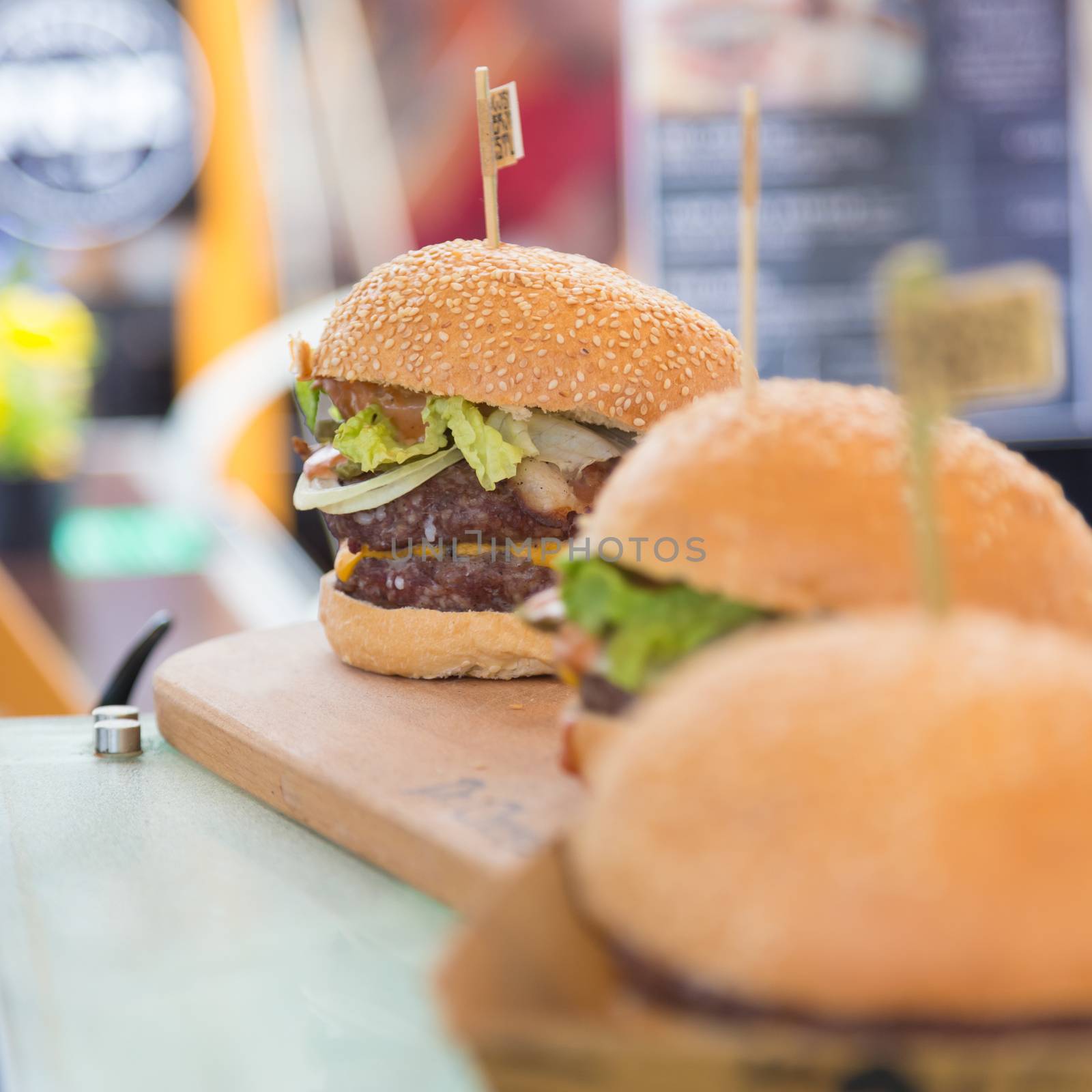 Beef burgers being served on food stall on open kitchen international food festival event of street food.
