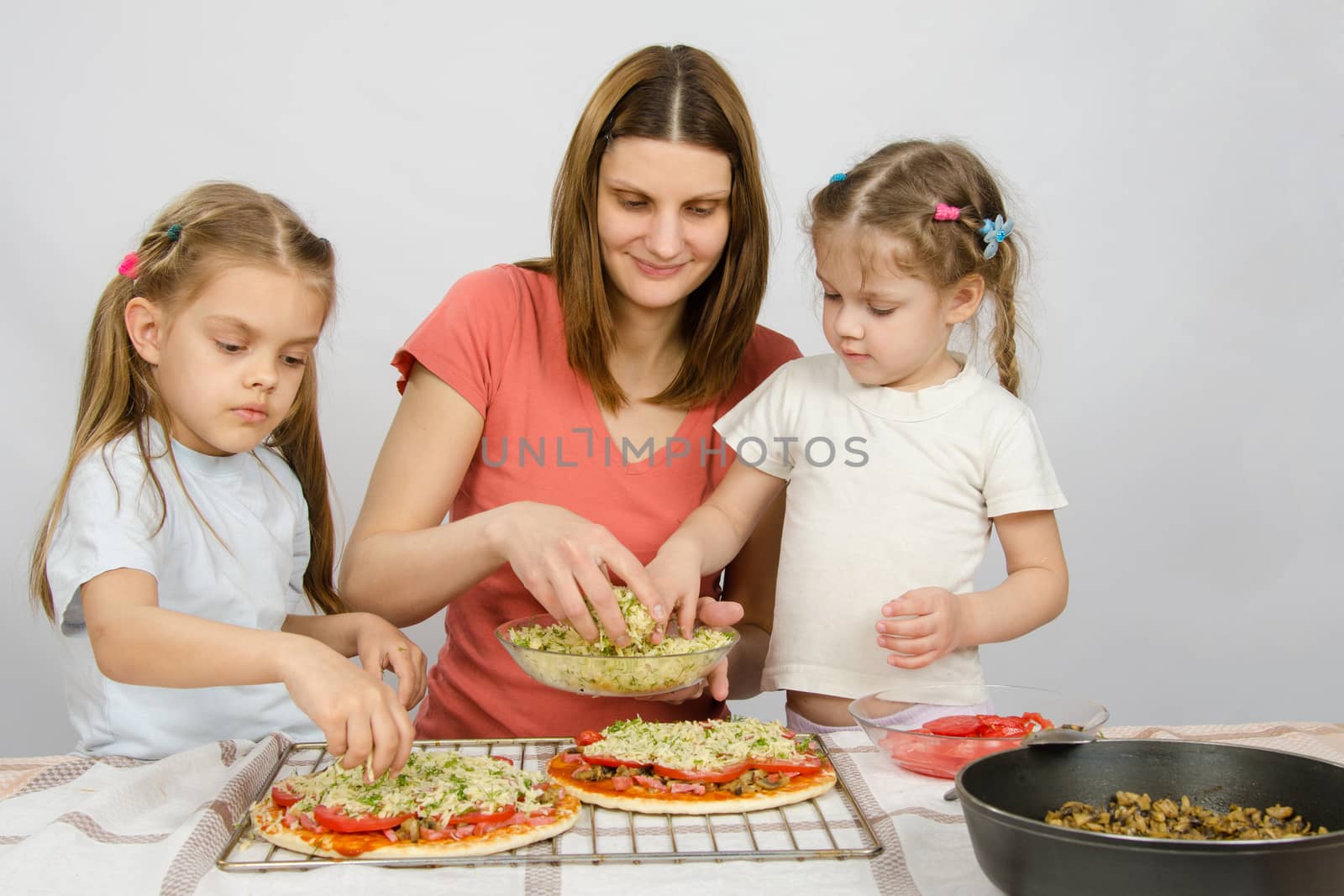 Mom with two young assistants make pizza by Madhourse