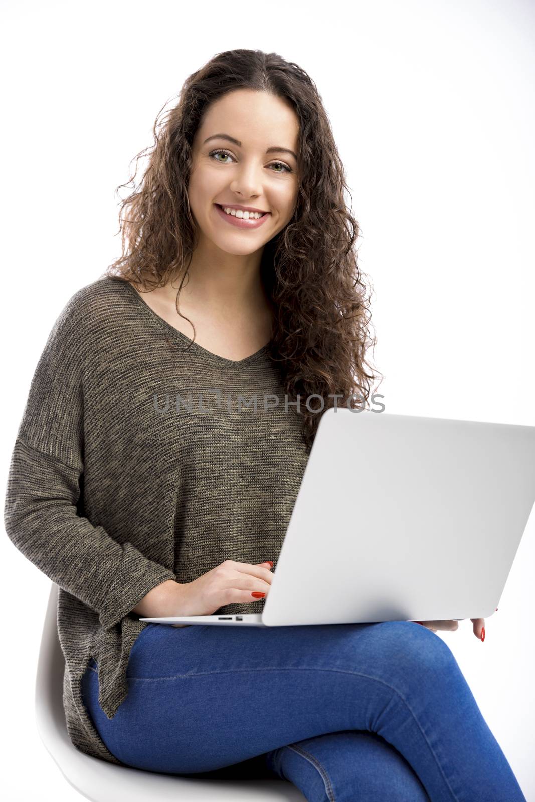 Beautiful and happy woman working with a laptop, isolated over white background 