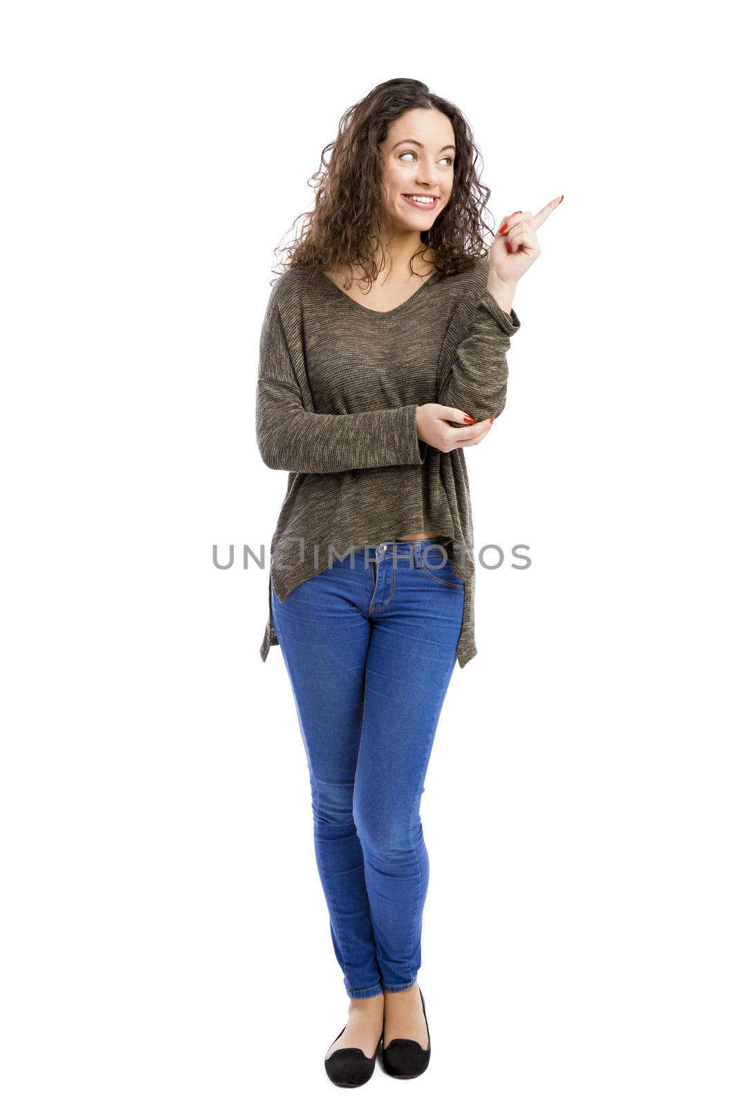 Beautiful and happy woman thinking and pointing to the side, isolated over white background 