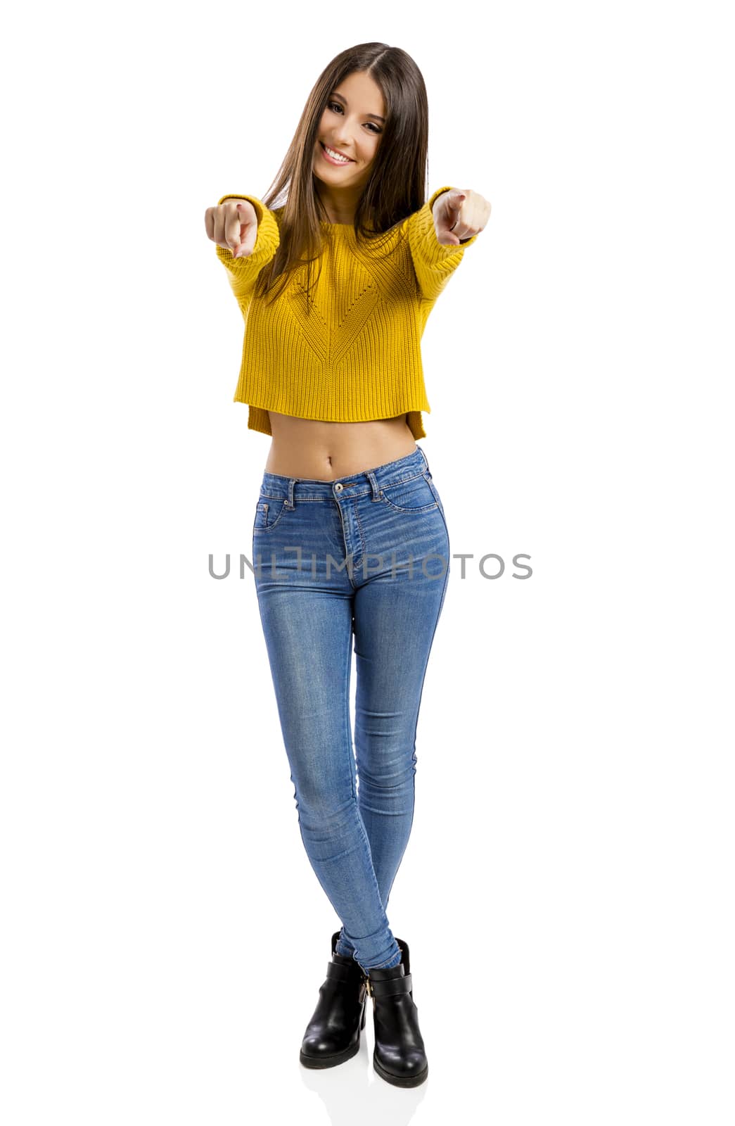 Beautiful and happy teenage girl pointing, isolated over white background 