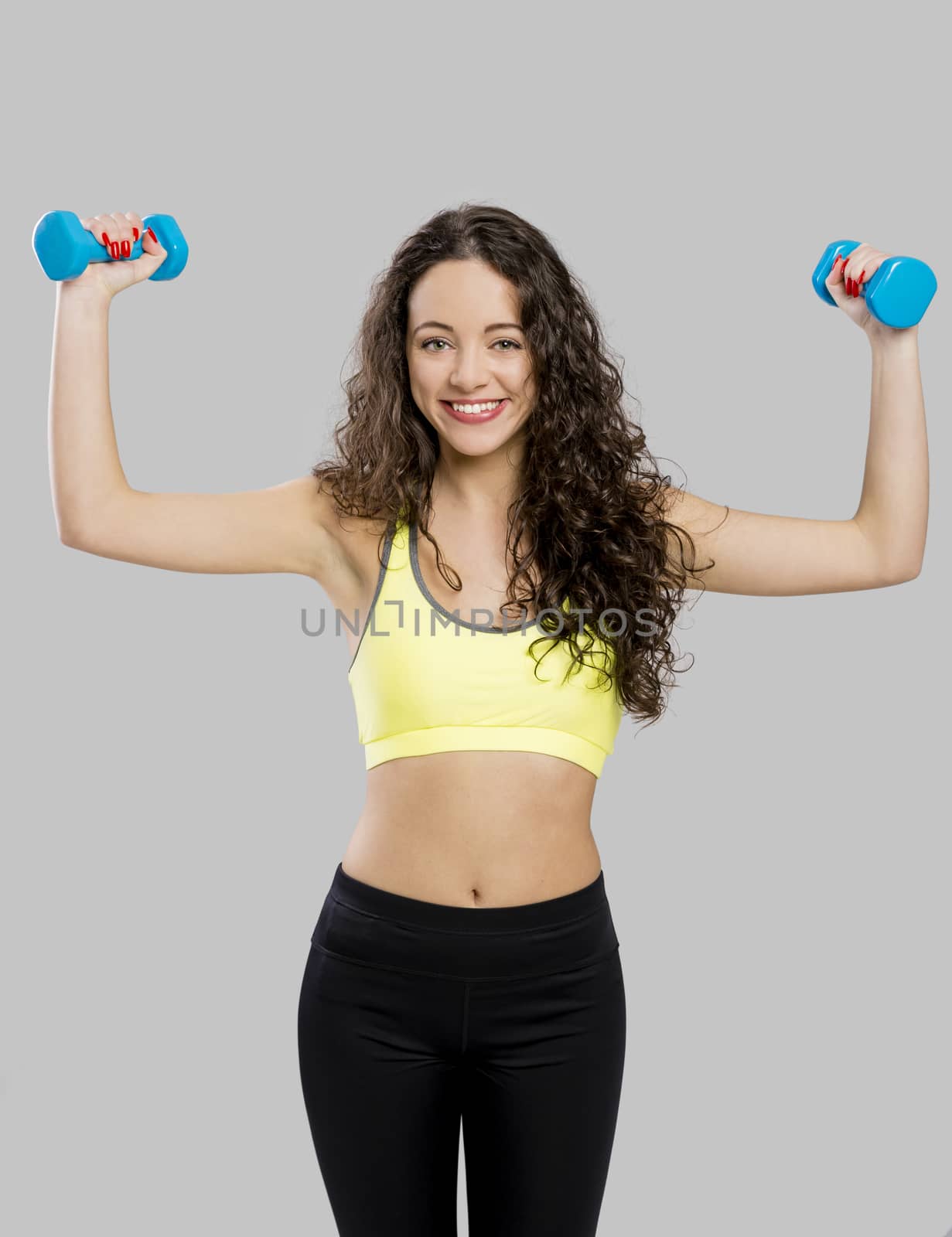 Beautiful sporty woman doing exercises with weights