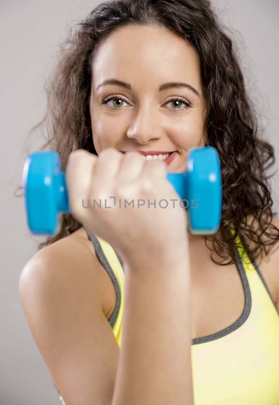 Beautiful sporty woman doing exercises with weights