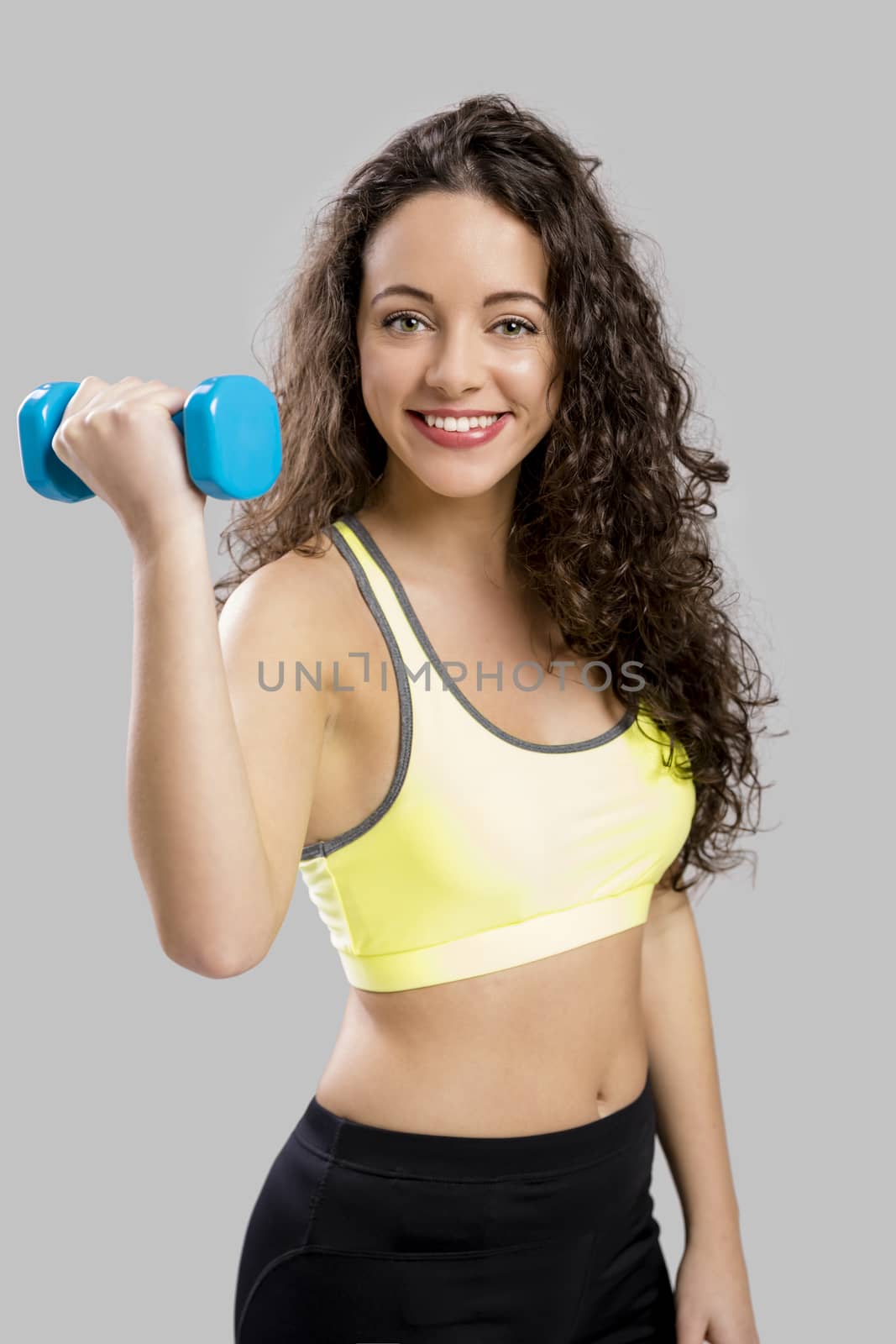 Beautiful sporty woman doing exercises with weights