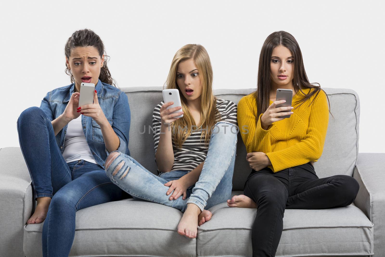 Happy teen girls at home using cellphone