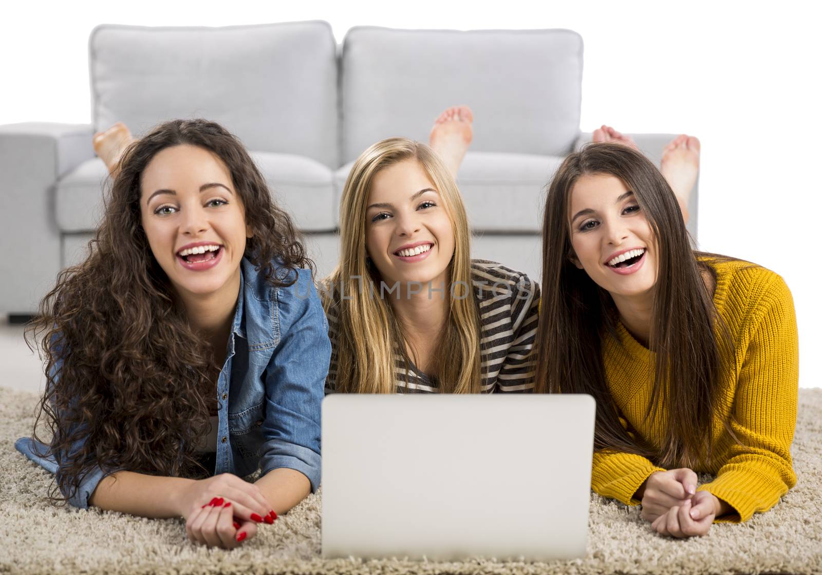 Happy teen girls studying at home with a laptop