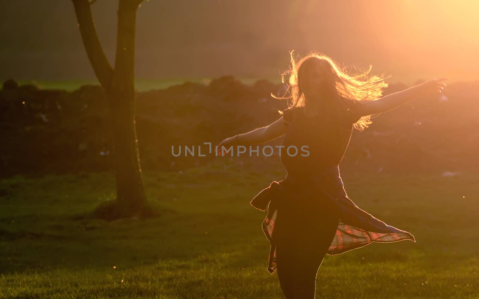 Teen girl jump against beautiful sunset in forest