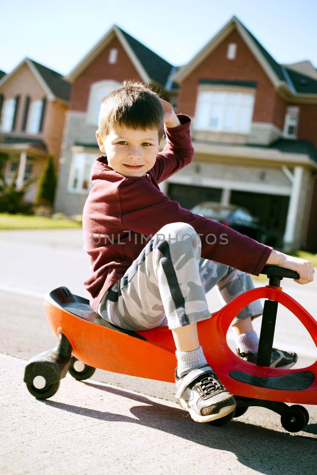small boy is having fun riding his toy on the street