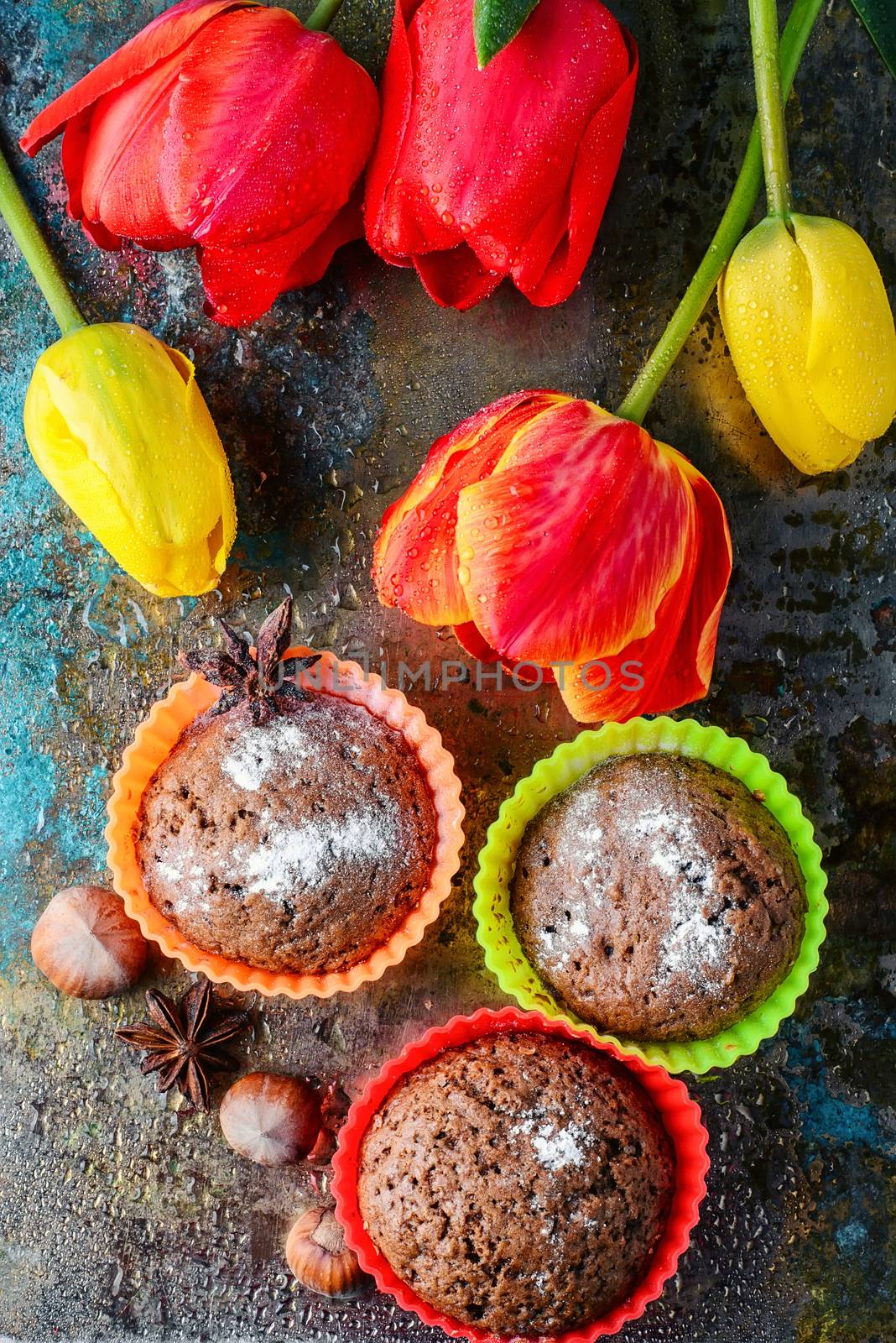 Sweet cupcake in silicone mould and a bouquet of spring tulips