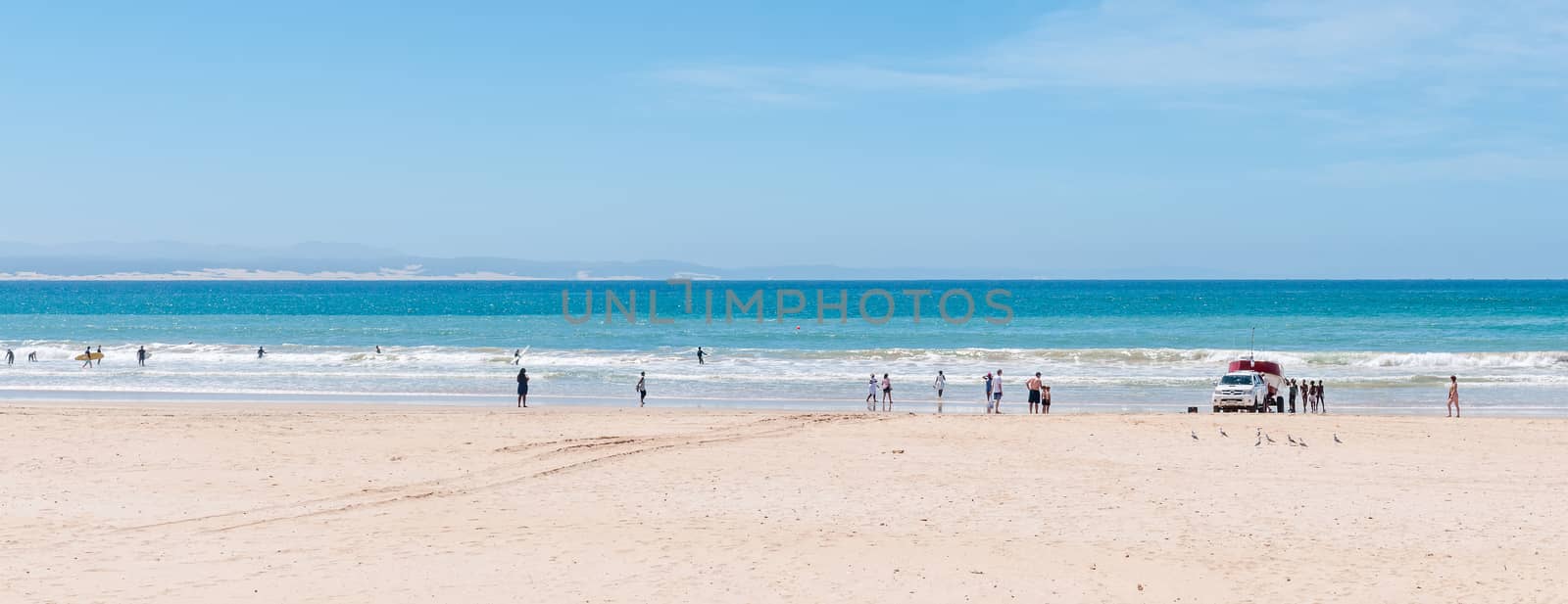 JEFFREYS BAY, SOUTH AFRICA - FEBRUARY 28, 2016:  A beach scene with a fishing boat being recovered. Unidentified people are looking on