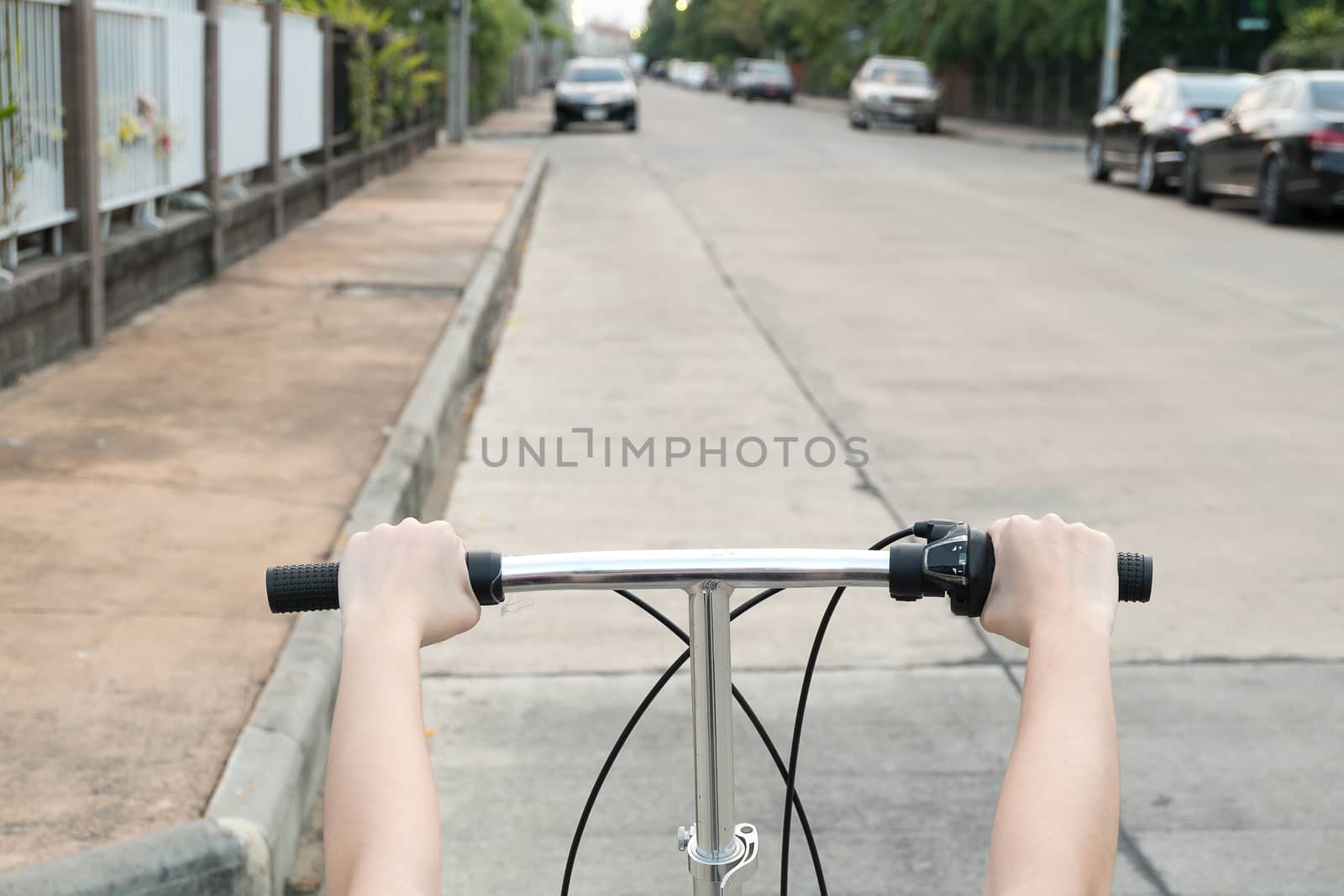 Rider driving bicycle on an asphalt road.  by suthee