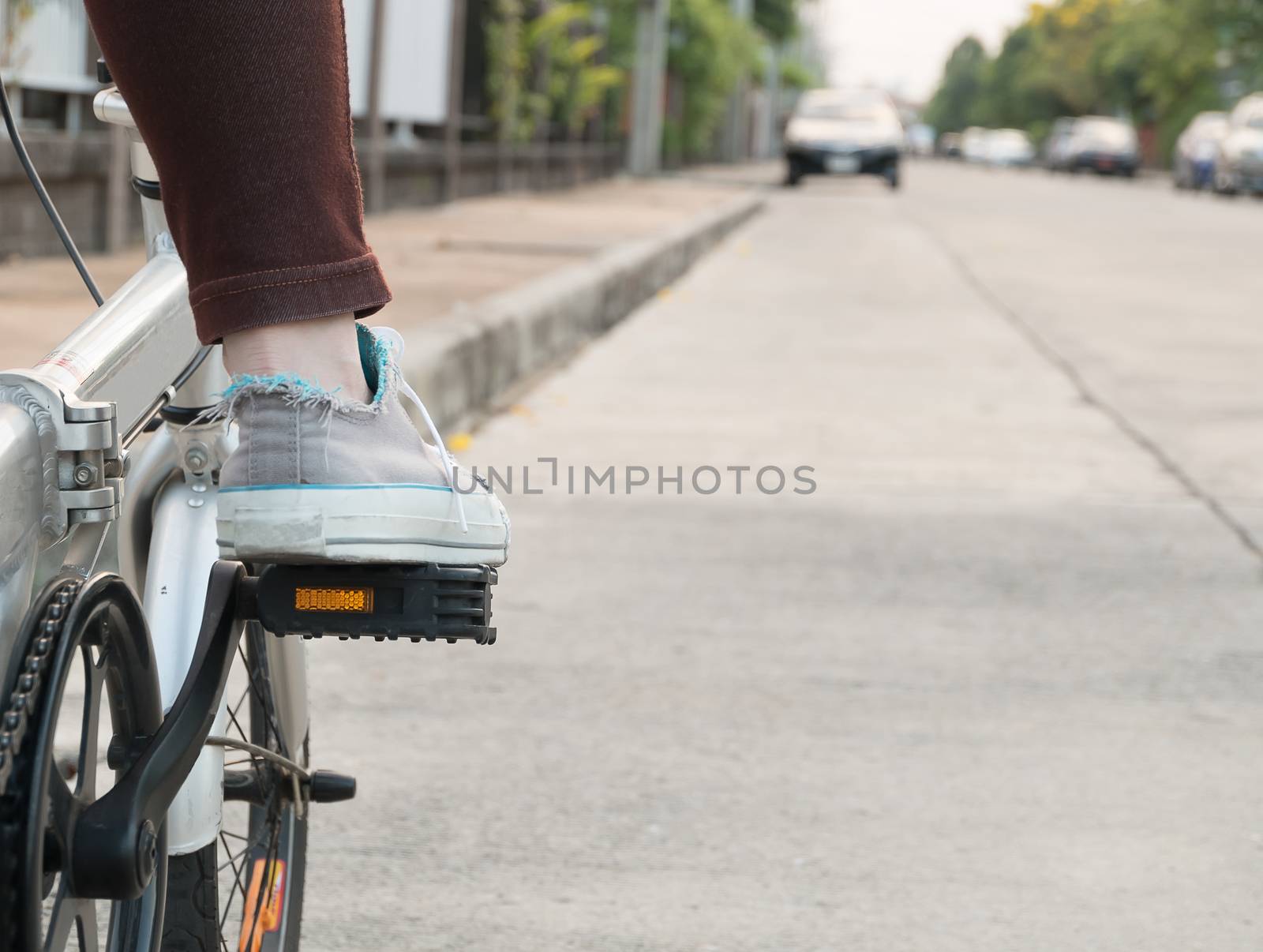 foot on pedal of bicycle ready for departure by suthee