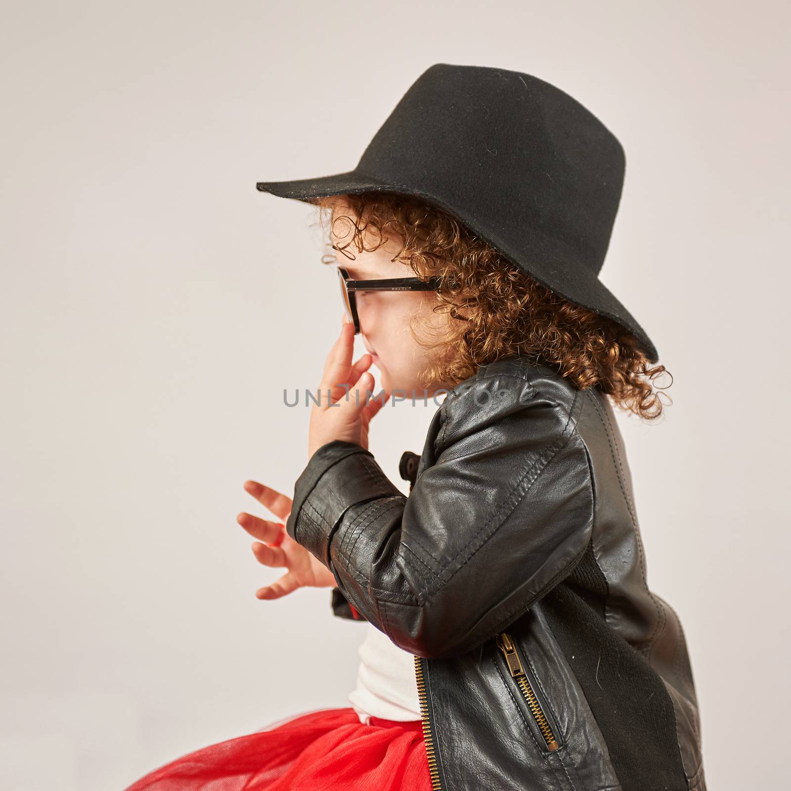 Little girl with black hat and sunglasses back view