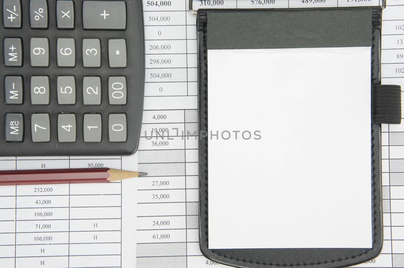 Notepad and brown pencil with calculator on finance account as background.