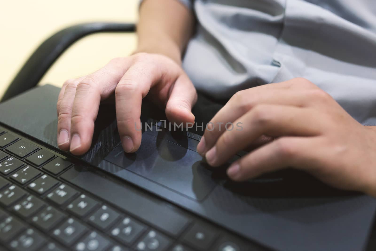 Adult man sit and typing laptop on your leg in home office .