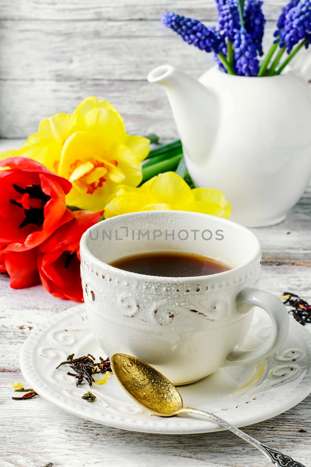 Herbal tea in a stylish mug and bouquet of tulips