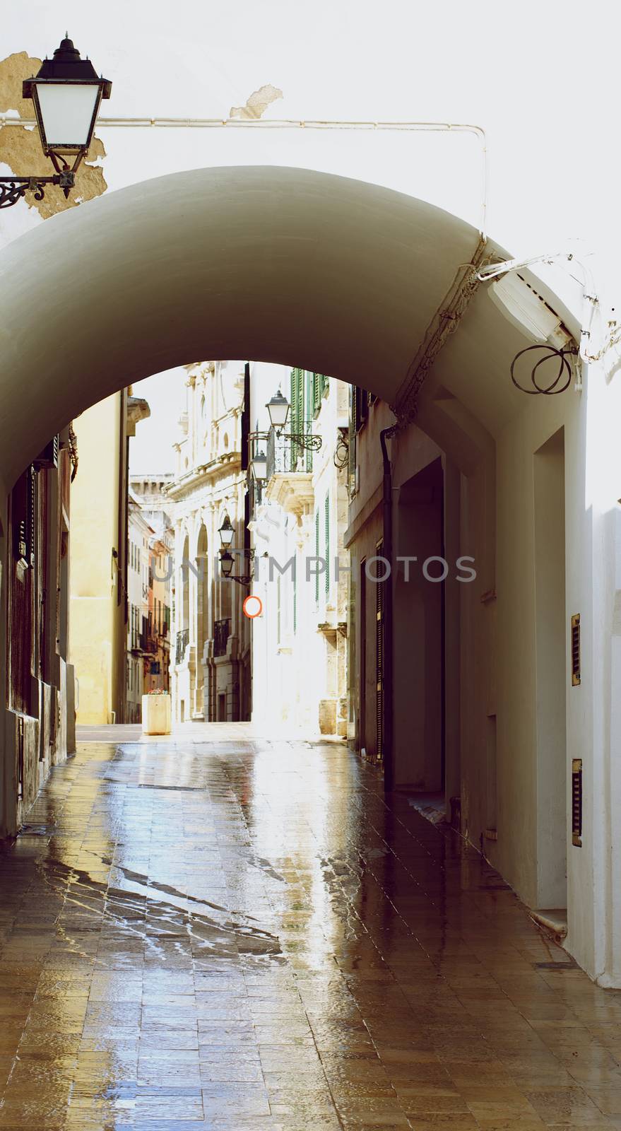 Entrance to Arch on Rainy Wet Cobblestone Street in Mahon, Menorca, Balearic Islands