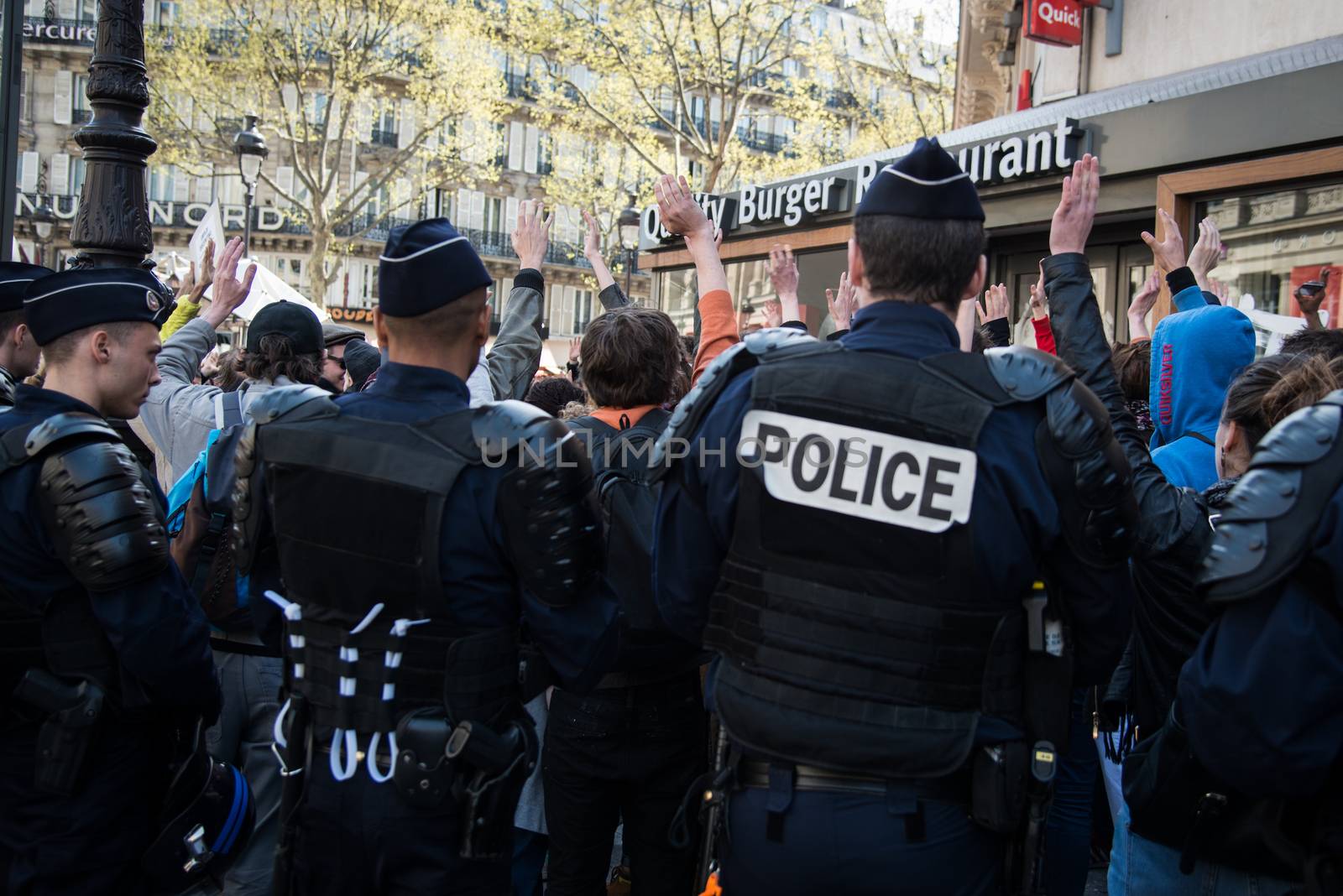 FRANCE, Paris : Demonstrators part of the Nuit Debout movement face police officers during a protest against split shifts and to demand wage increases in front of a fast food restaurant in Paris on April 20, 2016.