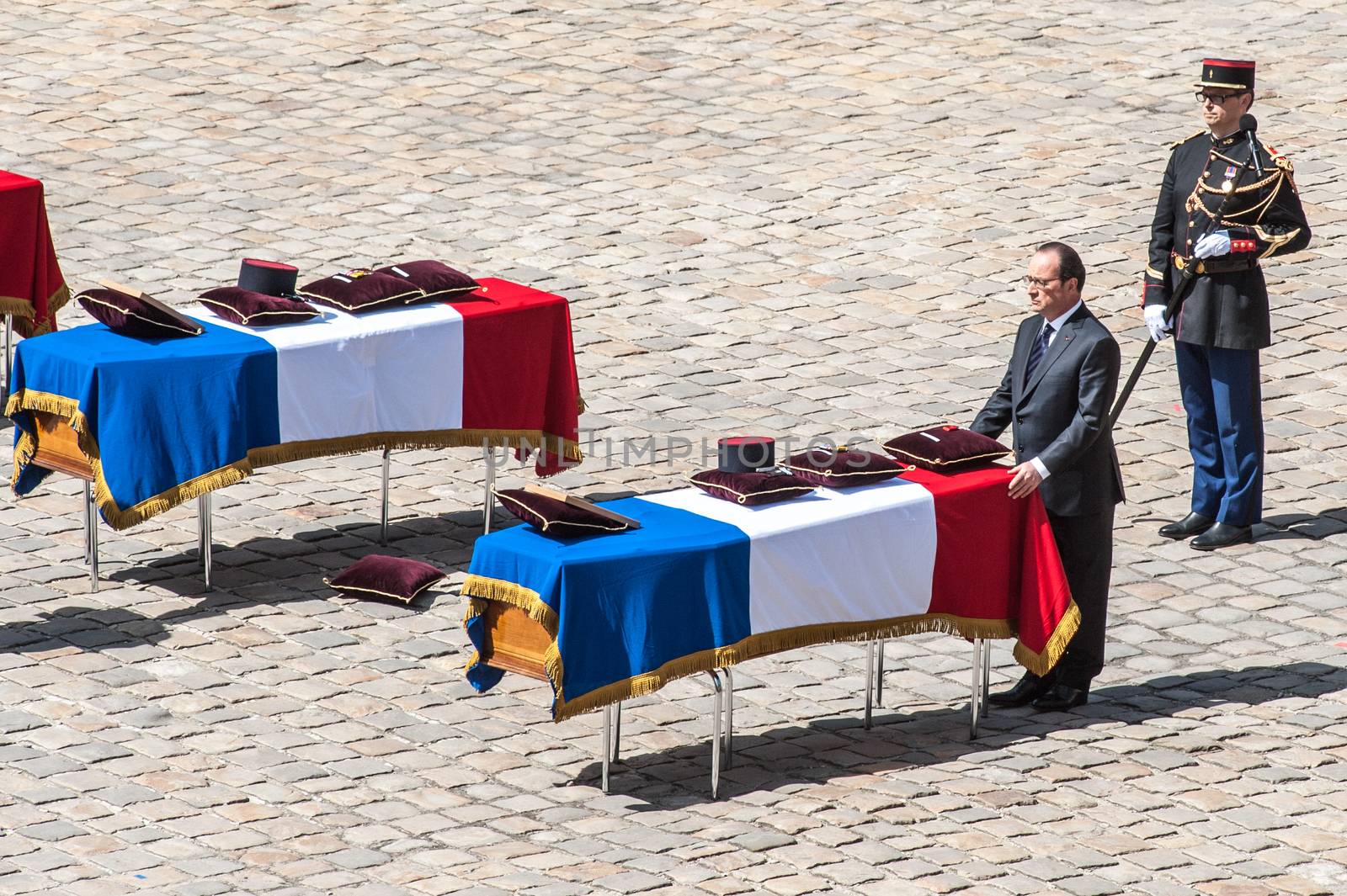 FRANCE, Paris : French President Francois Hollande pays his respect as he stands in front of one of the three coffins with the bodies of three French soldiers killed in service in Mali last week, during a solemn and national tribute ceremony at the Hotel des Invalides in Paris, on April 20, 2016.Three French peacekeeping soldiers died after their armoured car ran over a landmine in Mali, the French presidency said April 13, 2016. One soldier, Mickael Poo-Sing, was killed immediately in the blast on April 12, 2016 and President Francois Hollande learned with great sadness that two more soldiers had died in the west African country, a statement said. The car was leading a convoy of around 60 vehicles travelling to the northern desert town of Tessalit when it hit the mine, according to the French defence ministry. The troops were part of Operation Barkhane, under which France has some 3,500 soldiers deployed across five countries in the Sahel region, south of the Sahara desert, to combat the jihadist insurgency raging there.