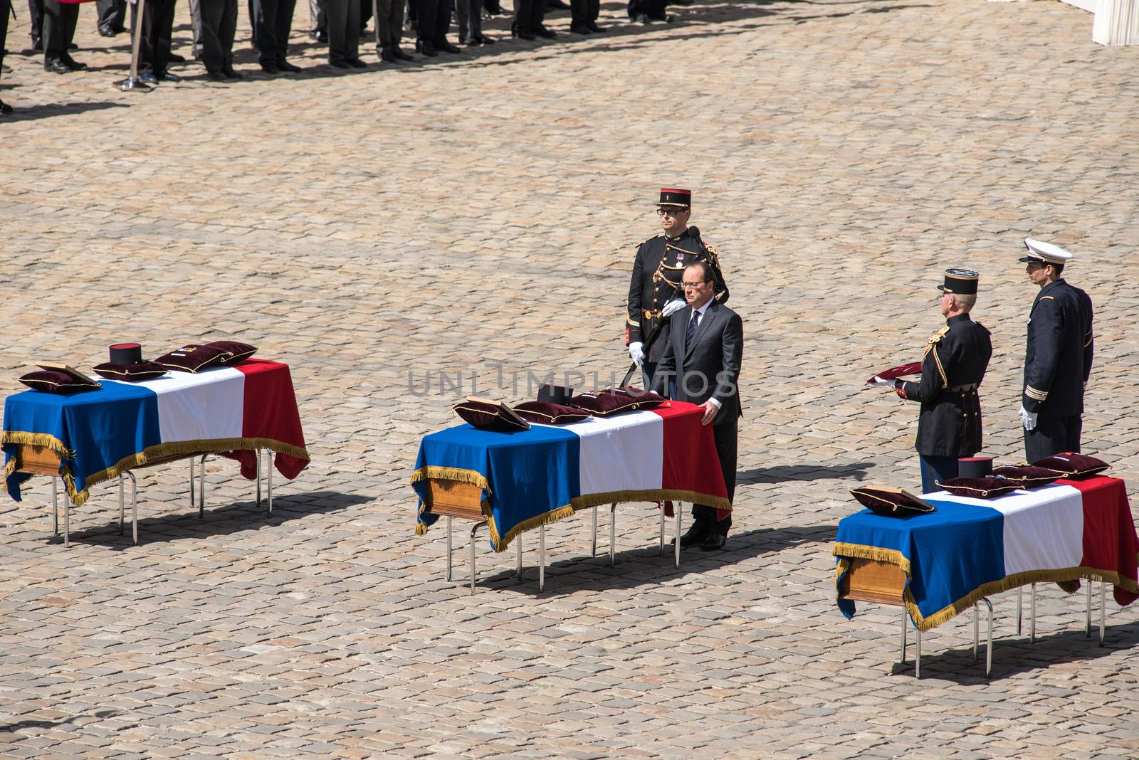 FRANCE, Paris : French President Francois Hollande pays his respect as he stands in front of one of the three coffins with the bodies of three French soldiers killed in service in Mali last week, during a solemn and national tribute ceremony at the Hotel des Invalides in Paris, on April 20, 2016.Three French peacekeeping soldiers died after their armoured car ran over a landmine in Mali, the French presidency said April 13, 2016. One soldier, Mickael Poo-Sing, was killed immediately in the blast on April 12, 2016 and President Francois Hollande learned with great sadness that two more soldiers had died in the west African country, a statement said. The car was leading a convoy of around 60 vehicles travelling to the northern desert town of Tessalit when it hit the mine, according to the French defence ministry. The troops were part of Operation Barkhane, under which France has some 3,500 soldiers deployed across five countries in the Sahel region, south of the Sahara desert, to combat the jihadist insurgency raging there. 