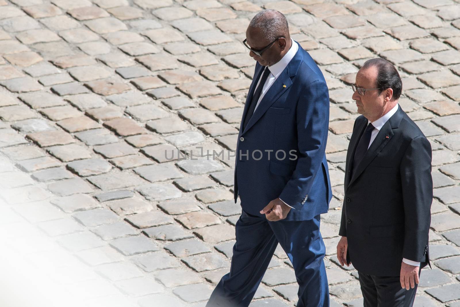 FRANCE, Paris : Malian President Ibrahim Boubacar Keita (L) holds hands with his French counterpart Francois Hollande as they attend solemn and national tribute ceremony at the Hotel des Invalides in Paris, on April 20, 2016 in honour of the three French soldiers killed in service in Mali last week.Three French peacekeeping soldiers died after their armoured car ran over a landmine in Mali, the French presidency said April 13, 2016. One soldier, Mickael Poo-Sing, was killed immediately in the blast on April 12, 2016 and President Francois Hollande learned with great sadness that two more soldiers had died in the west African country, a statement said. The car was leading a convoy of around 60 vehicles travelling to the northern desert town of Tessalit when it hit the mine, according to the French defence ministry. The troops were part of Operation Barkhane, under which France has some 3,500 soldiers deployed across five countries in the Sahel region, south of the Sahara desert, to combat the jihadist insurgency raging there.