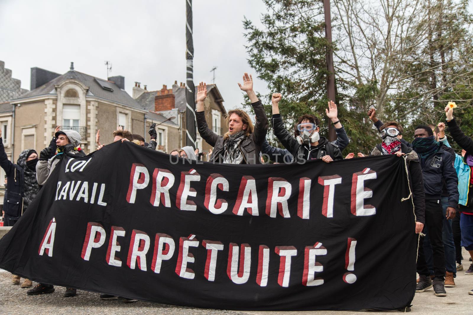 FRANCE, Nantes : Protesters hold a banner reading Precariousness forever as they demonstrate in Nantes, western France, on April 20, 2016, against the government's planned labour law reforms.High school students and workers are protesting against the deeply unpopular labour reforms that have divided the Socialist government and raised hackles in a country accustomed to iron-clad job security.