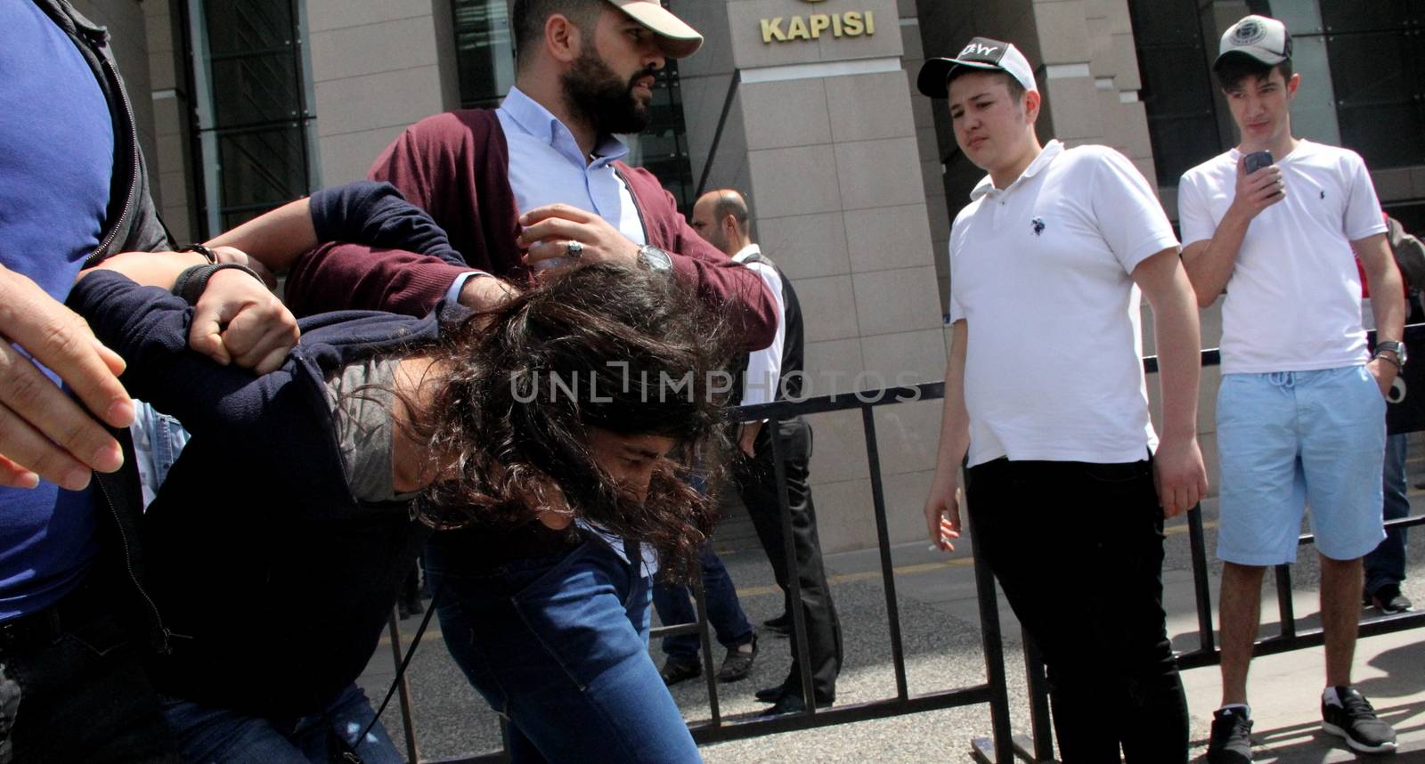 TURKEY, Istanbul: Policemen arrest a protester outside the courthouse in Istanbul, Turkey, on April 20, 2016, during the second hearing in the trial of a police officer accused of killing Dilek Doğan. Dogan died after being shot dead during a police raid of her family's house in Istanbul's Sariyer district, last October. Dozens of protesters, who shouted Murderers of Dilek must be tried, has been taken into custody by police. 