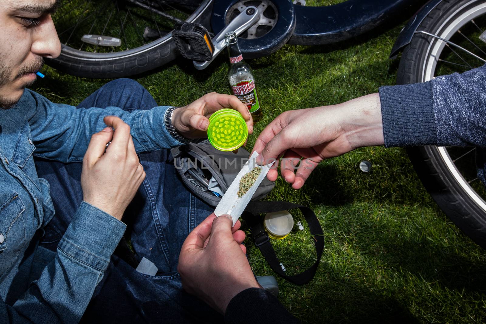 UNITED-KINGDOM, London: Men prepare a reefer as hundreds of pro-cannabis supporters gather in Hyde Park, in London for 4/20 day, a giant annual smoke-in  on April 20, 2016. 