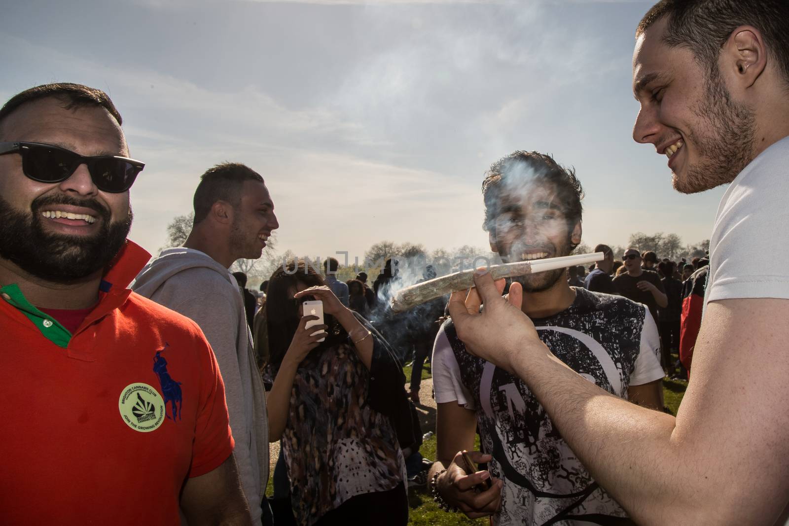 UNITED-KINGDOM, London: A man smokes a large reefer as hundreds of pro-cannabis supporters gather in Hyde Park, in London for 4/20 day, a giant annual smoke-in  on April 20, 2016. 