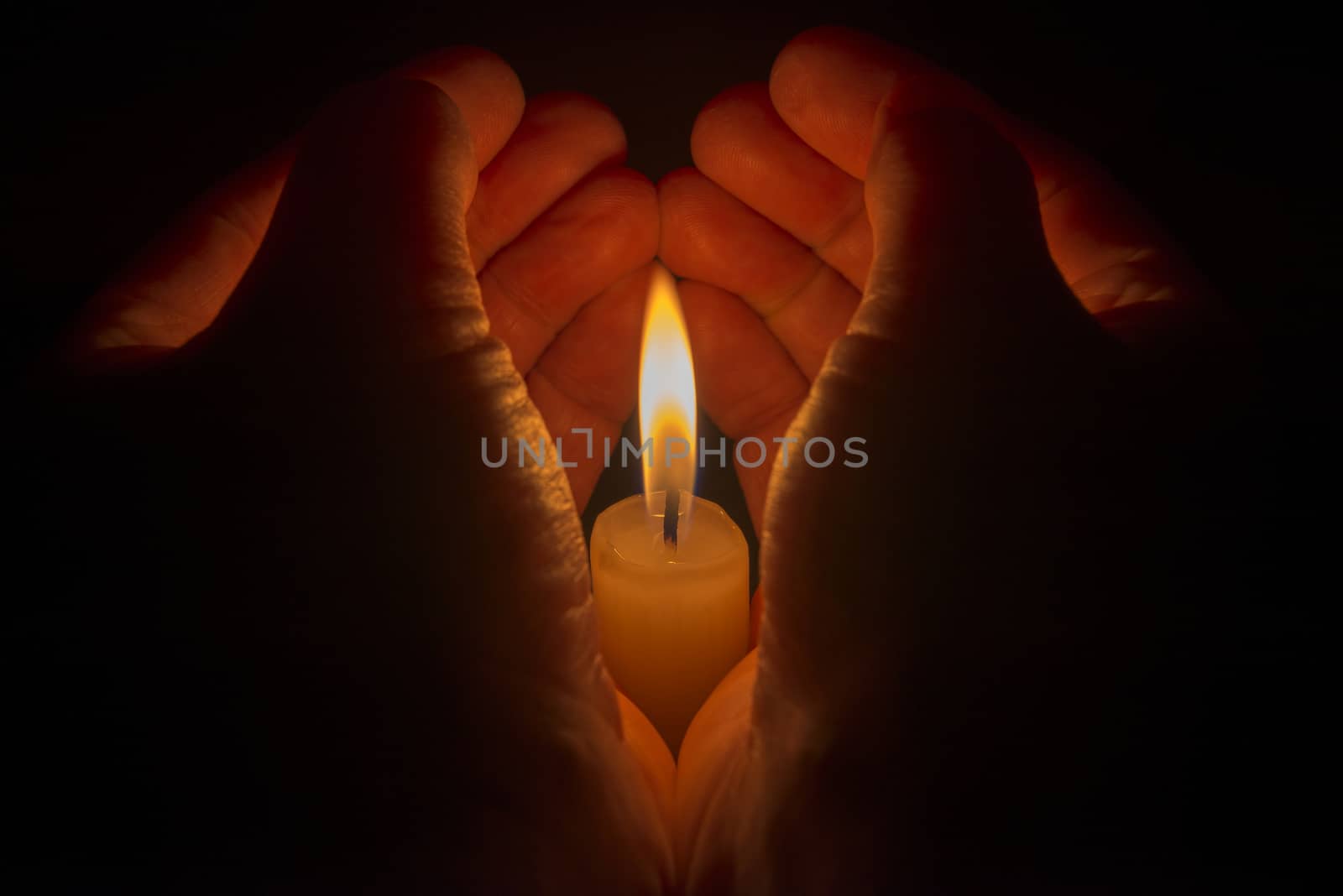 Protective hands around a burning candle
 by Tofotografie