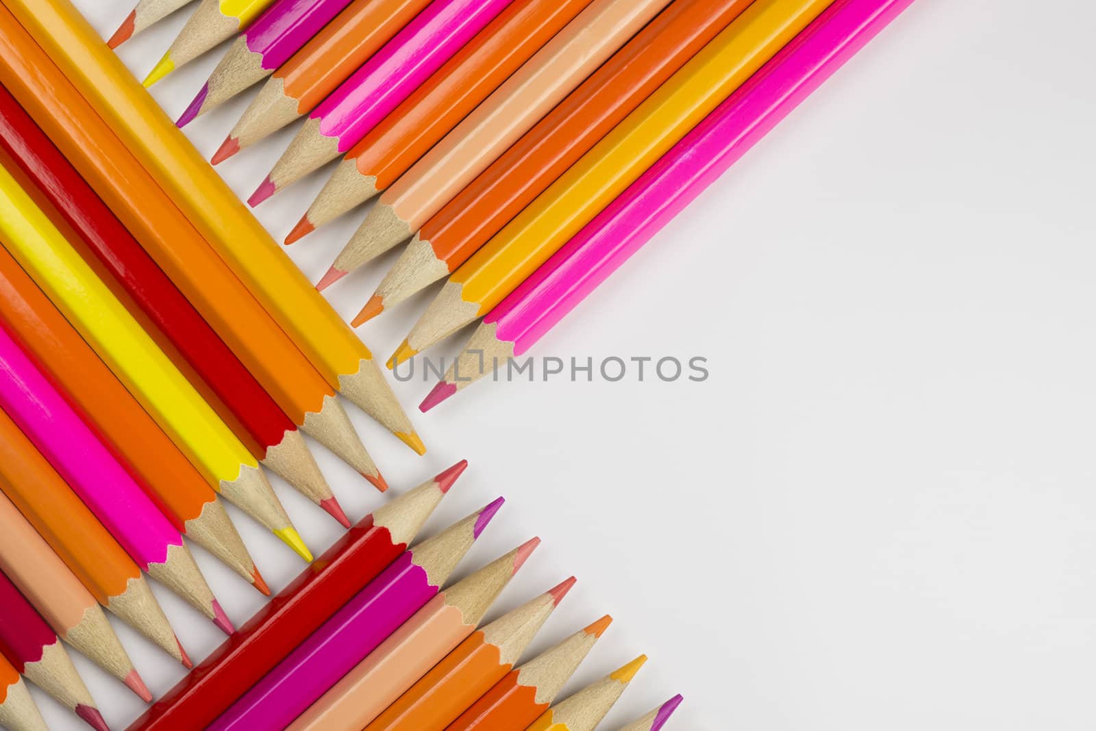 Abstract composition of a set wooden colour pencils against a white background
