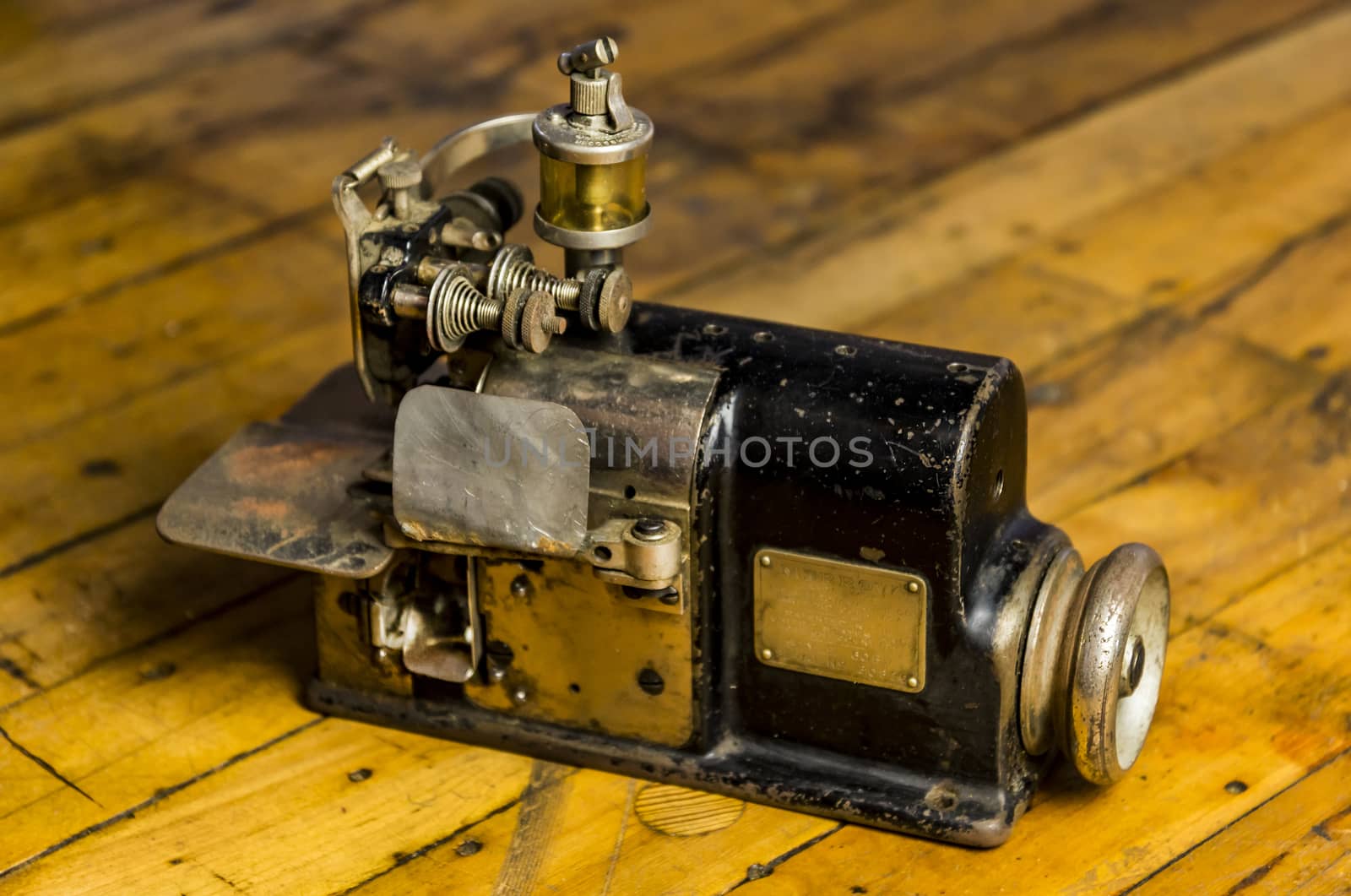 Vintage industrial sewing machine isolated on wooden floor