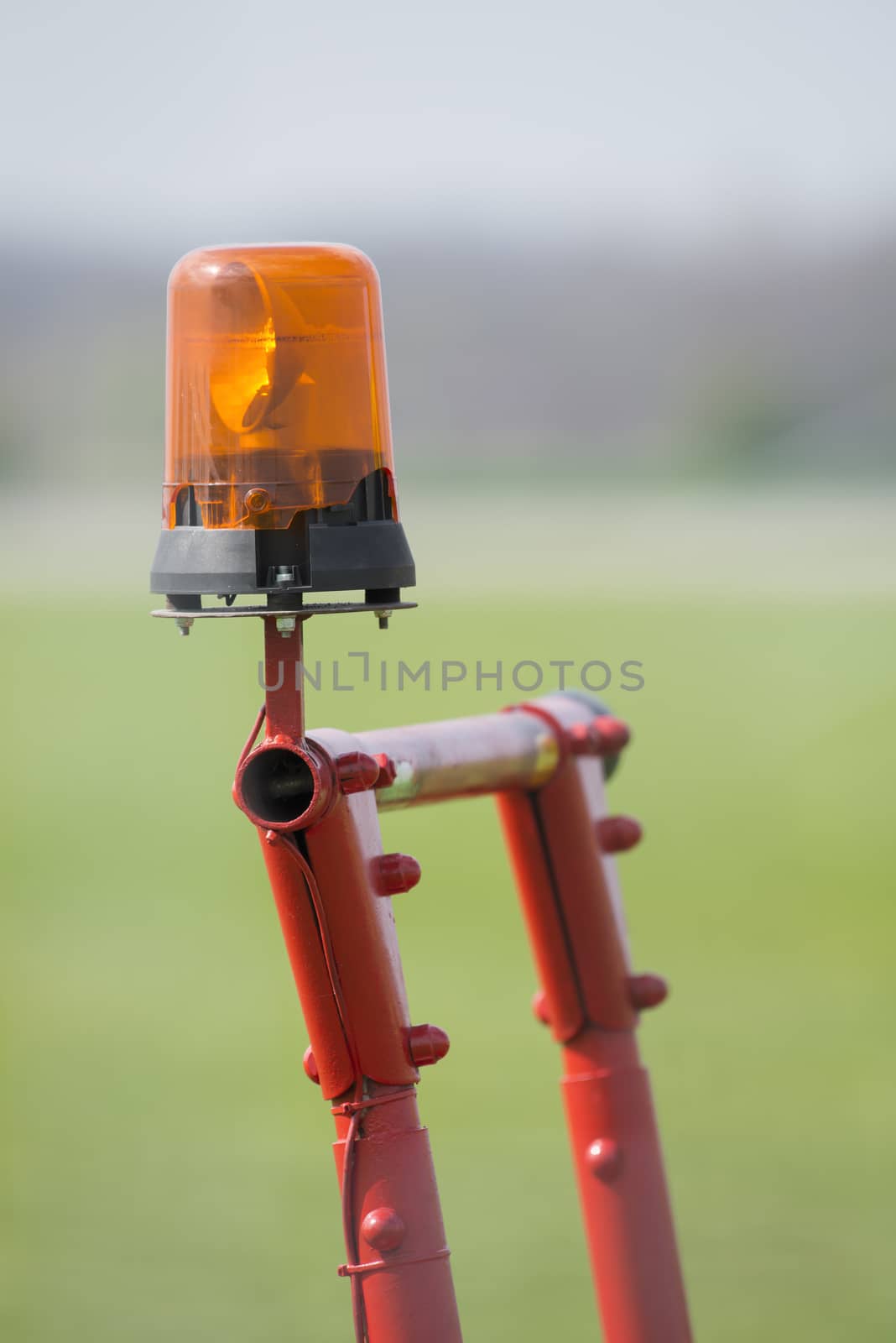 Orange flashing light on a cell red metal scaffolding

