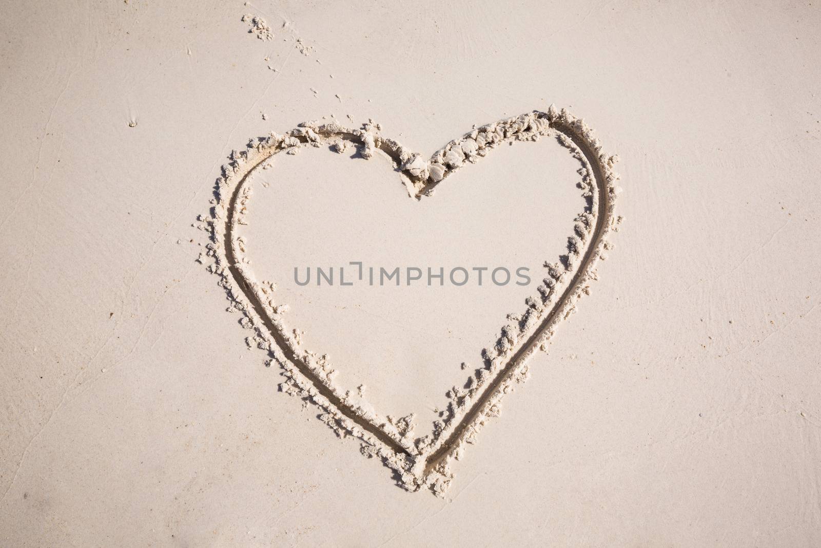 drawing heart symbol on the beach show romantic feeling