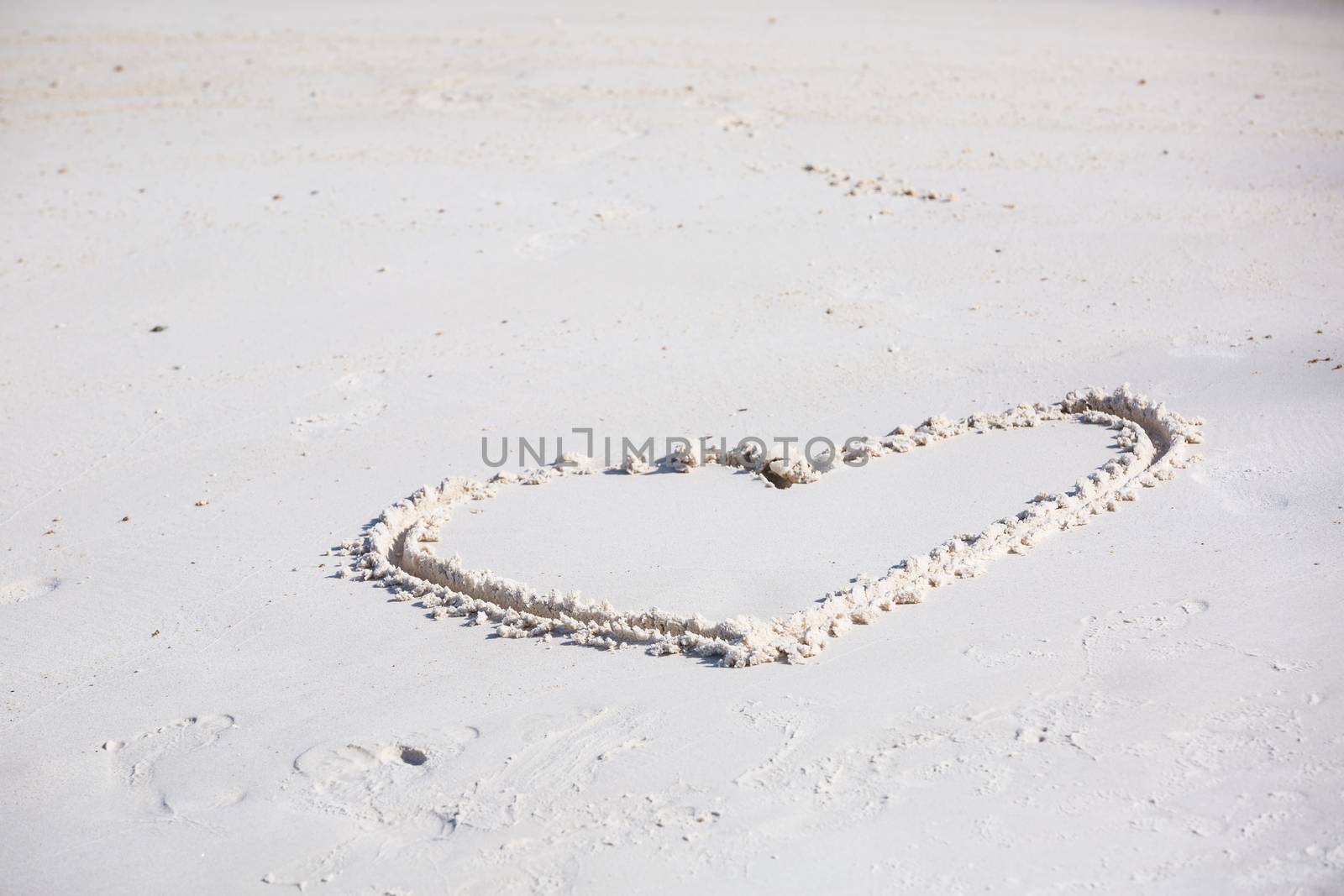 drawing heart symbol on the beach show romantic feeling