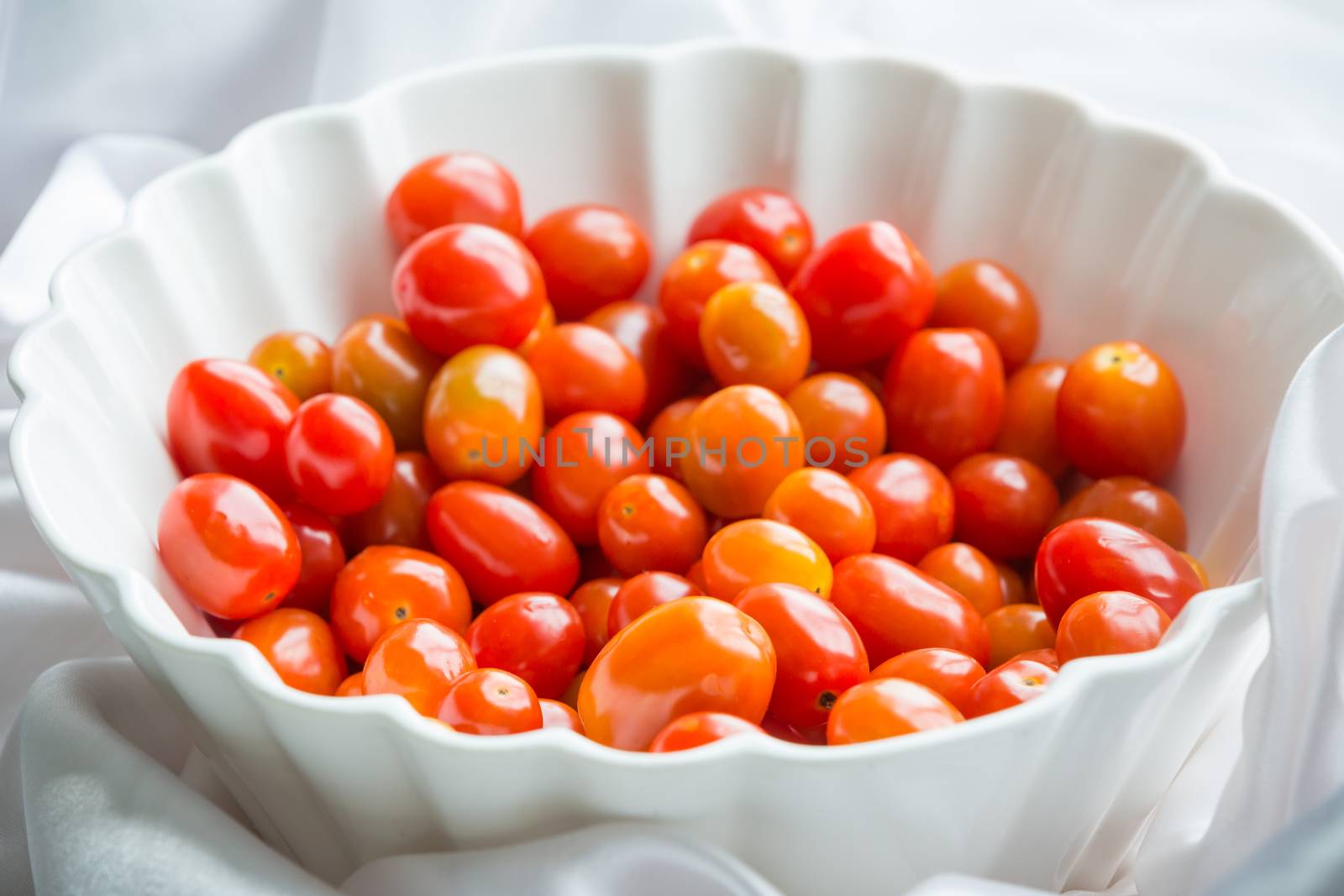 cherry tomato in white bowl on the table