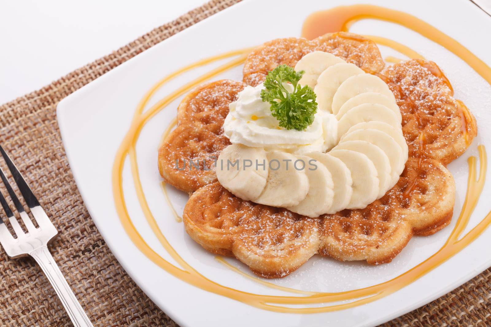 Banana waffle topping with maple syrup and whip cream