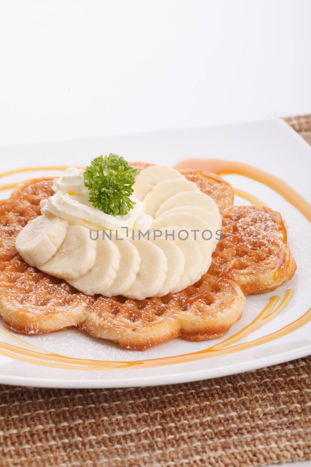 Banana waffle topping with maple syrup and whip cream