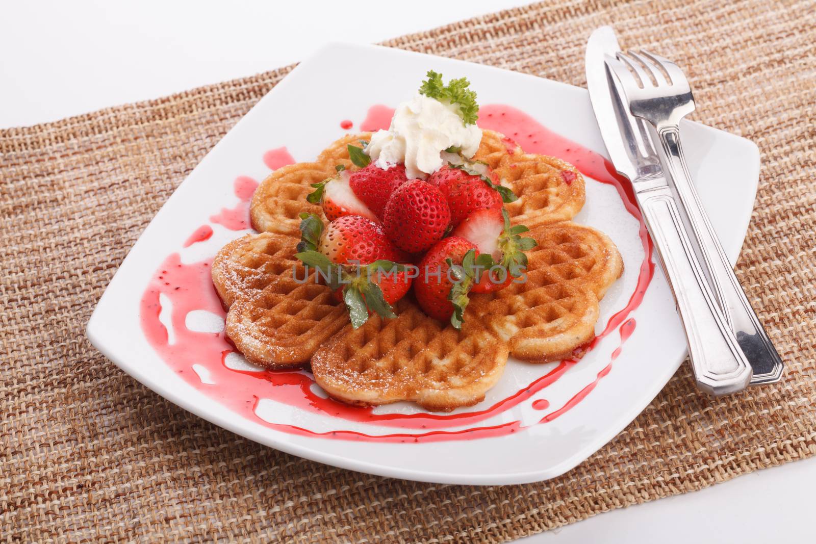 waffle topping with strawberry and decoration with strawberry sauce