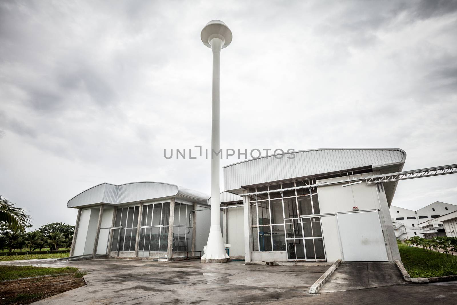 exterior of white factory with tall water tank