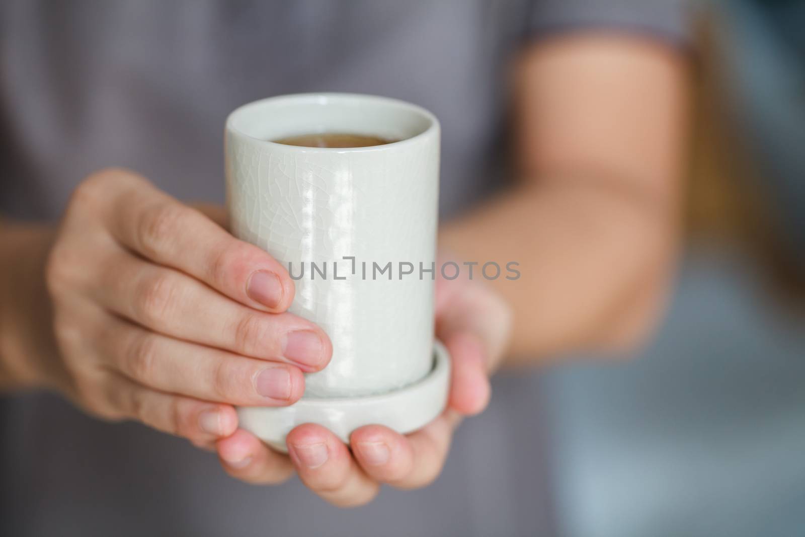 a woman is offering a cup of tea