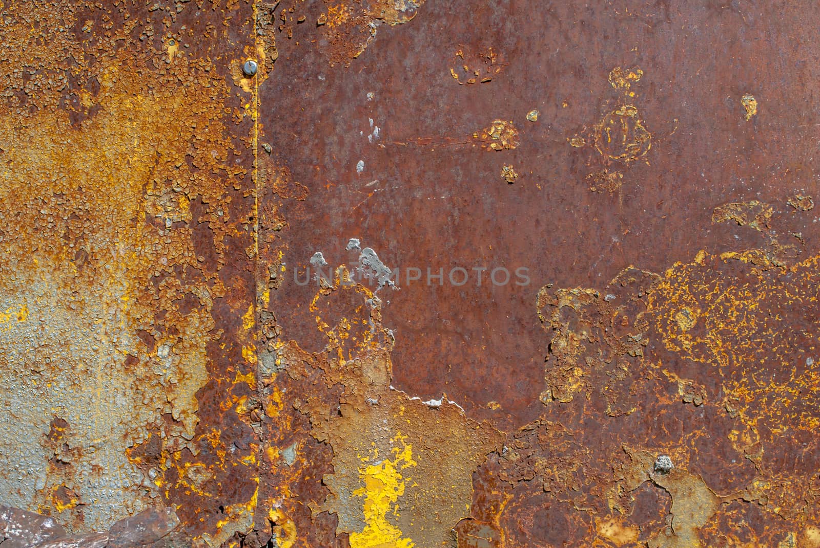 rusty iron surface covered with old chipped yellow color paint, which has long been influenced by different climatic conditions