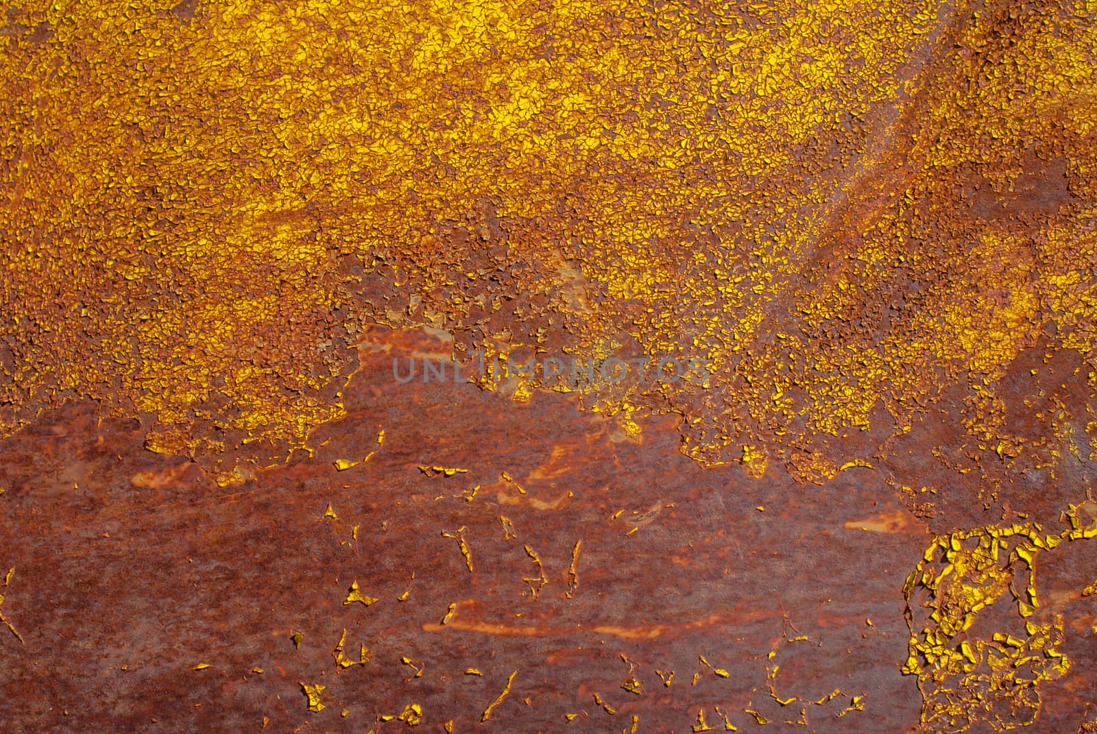 rusty iron surface covered with old chipped yellow color paint, which has long been influenced by different climatic conditions